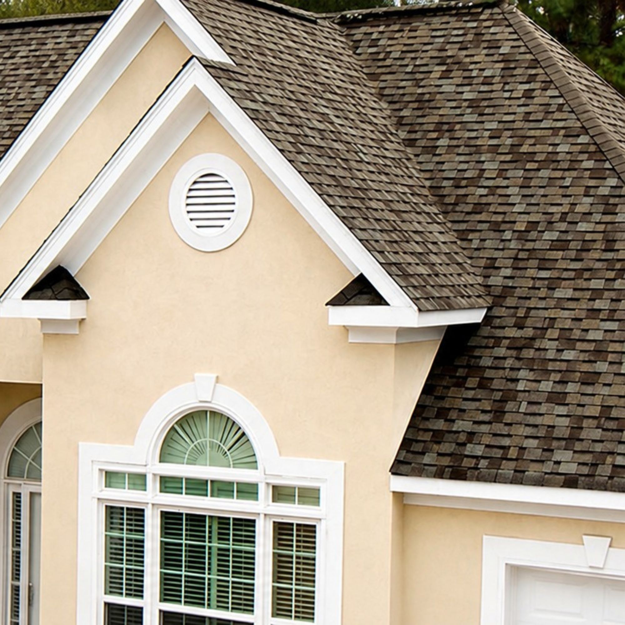 Architectural asphalt shingles on a gabled stucco home
