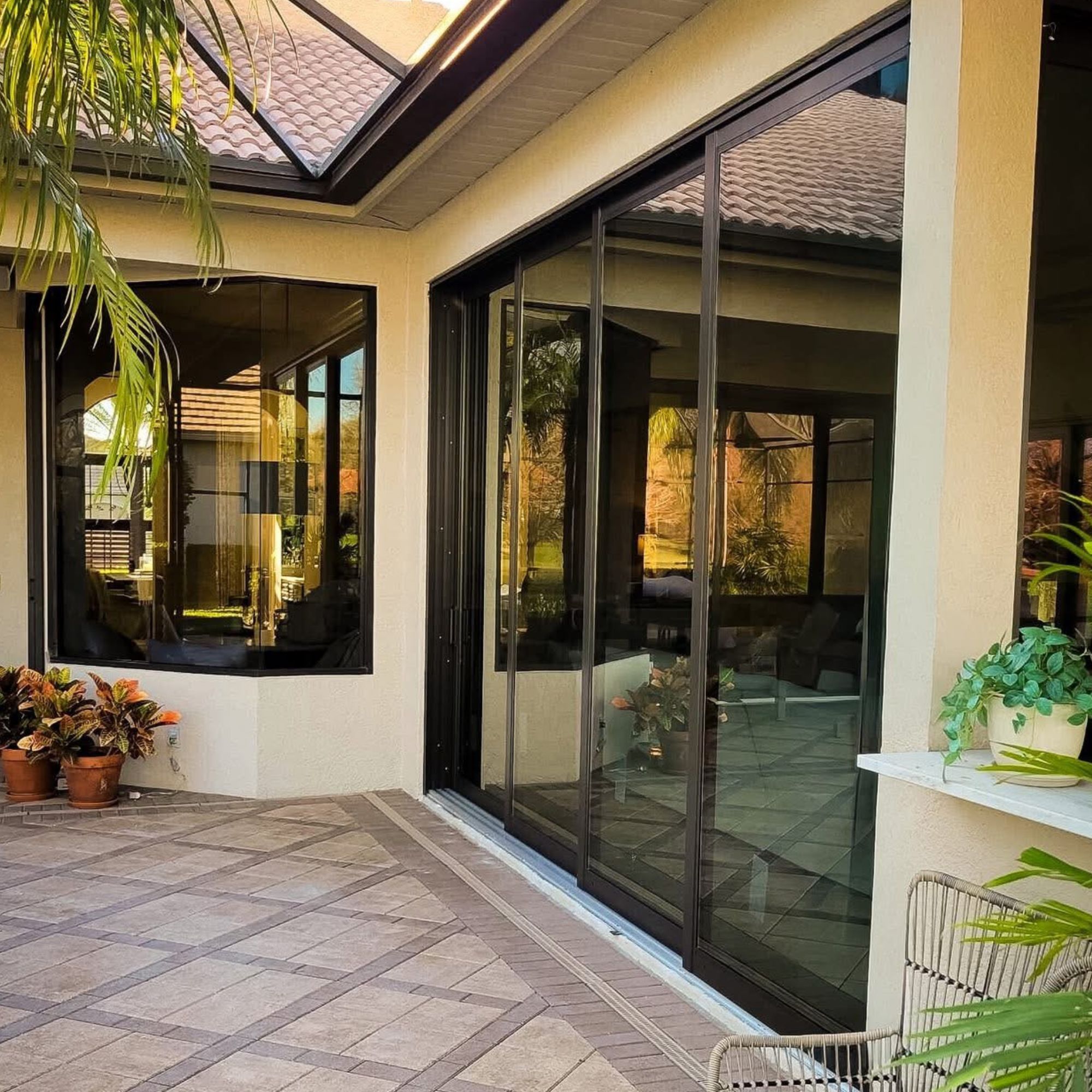 Dark-framed sliding patio doors along a paver lanai