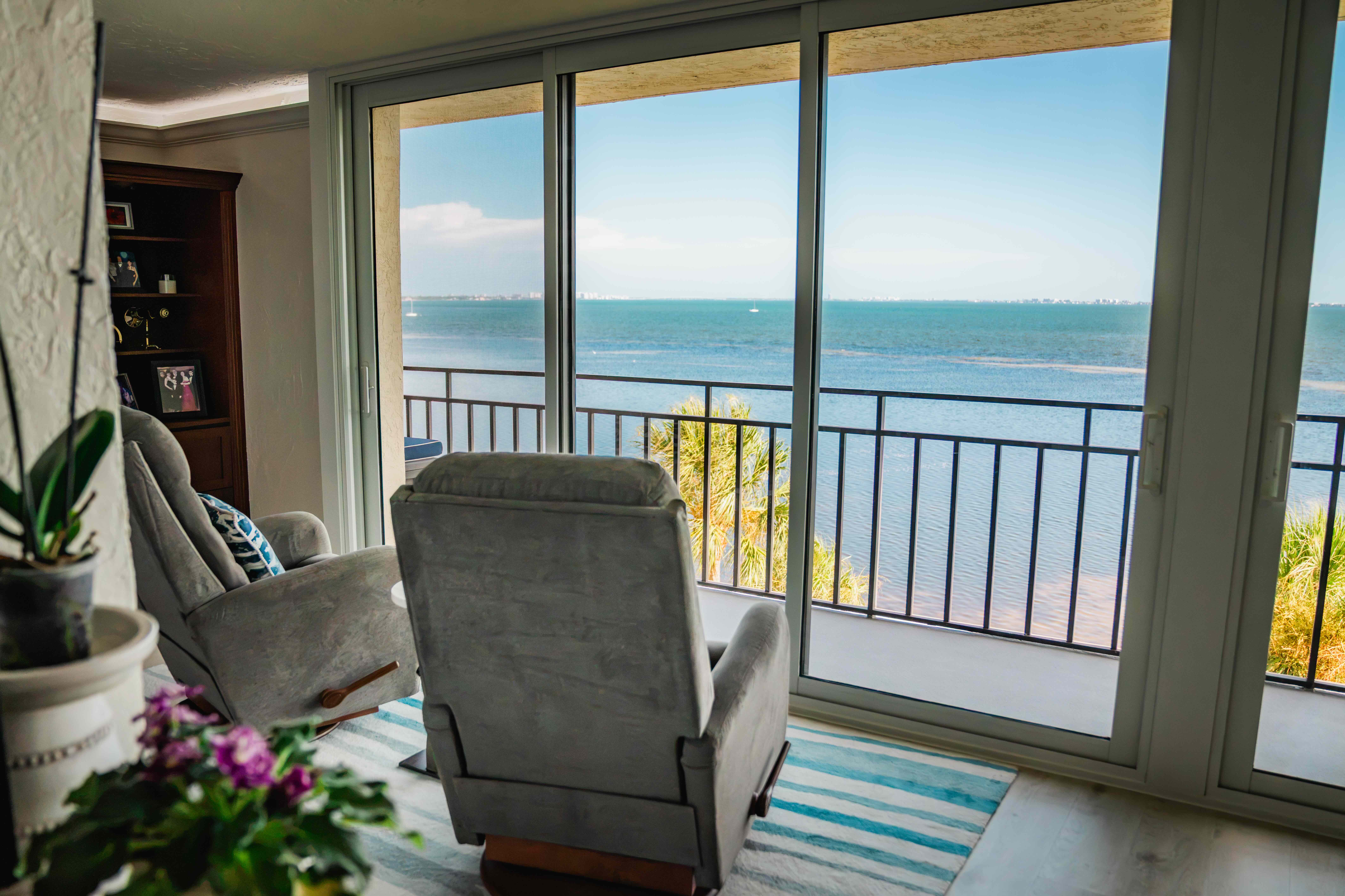 Sliding glass patio doors opening onto a balcony with wide bay views