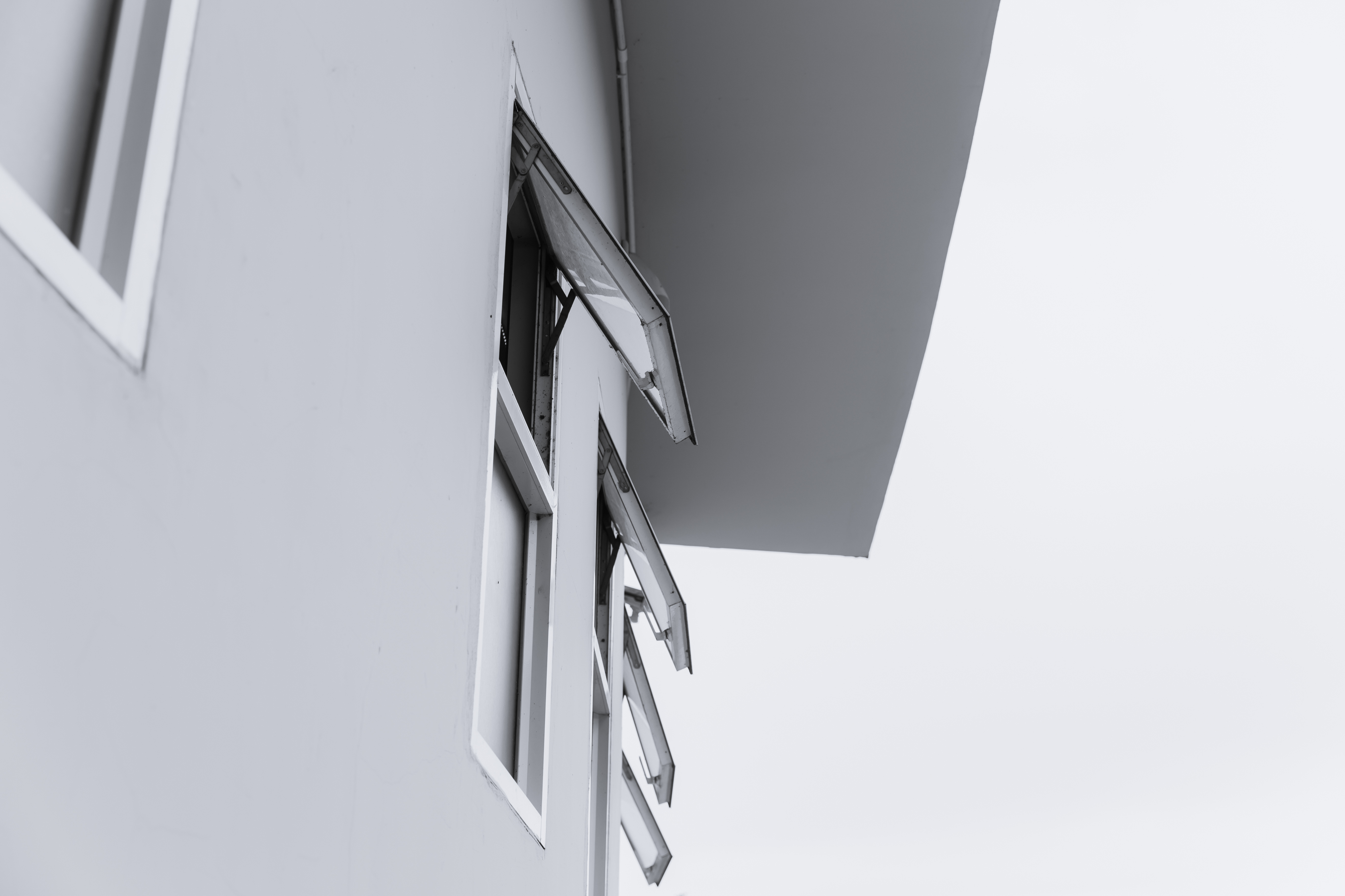 Awning windows cranked open along a white exterior wall