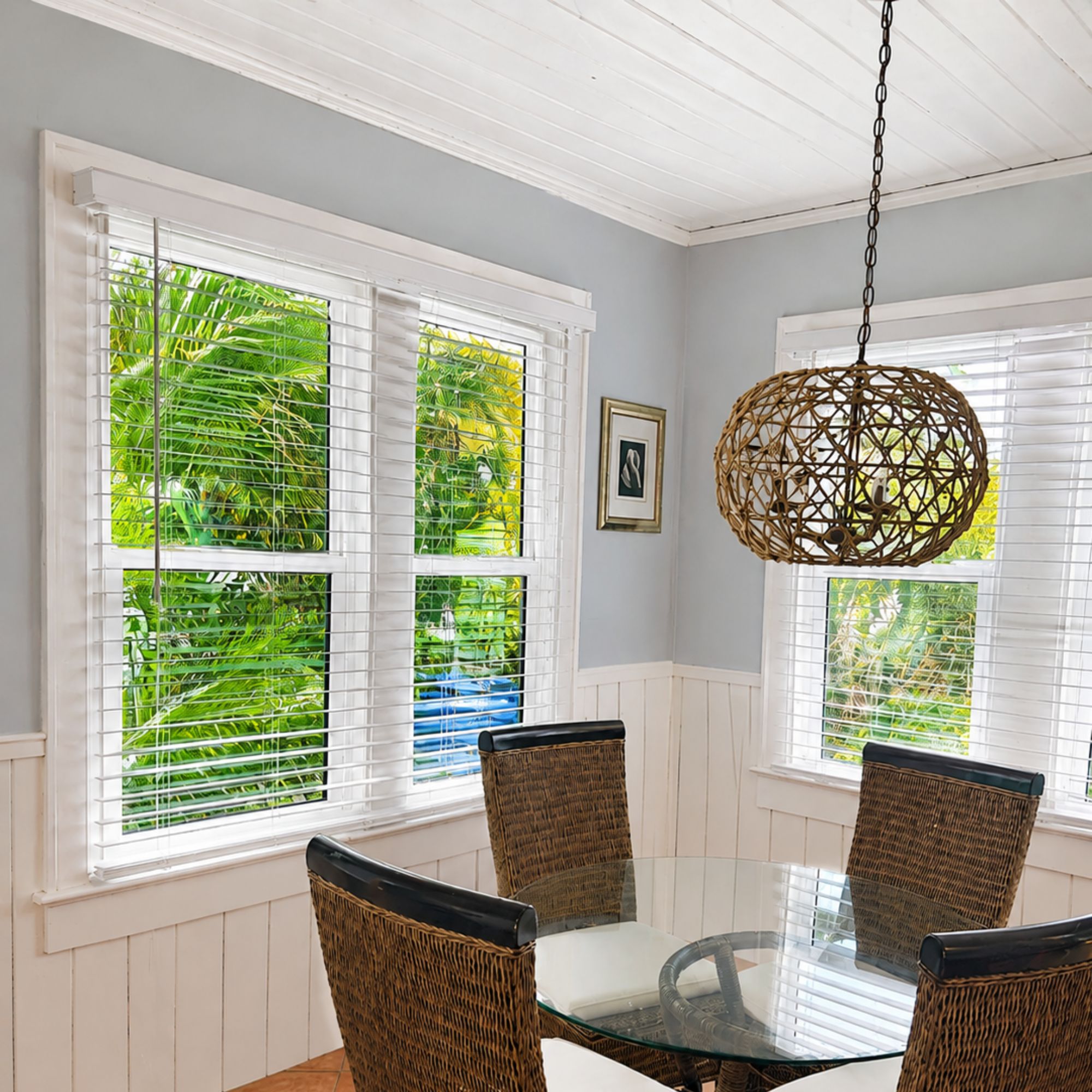 Dining nook with white single hung windows and a woven pendant light