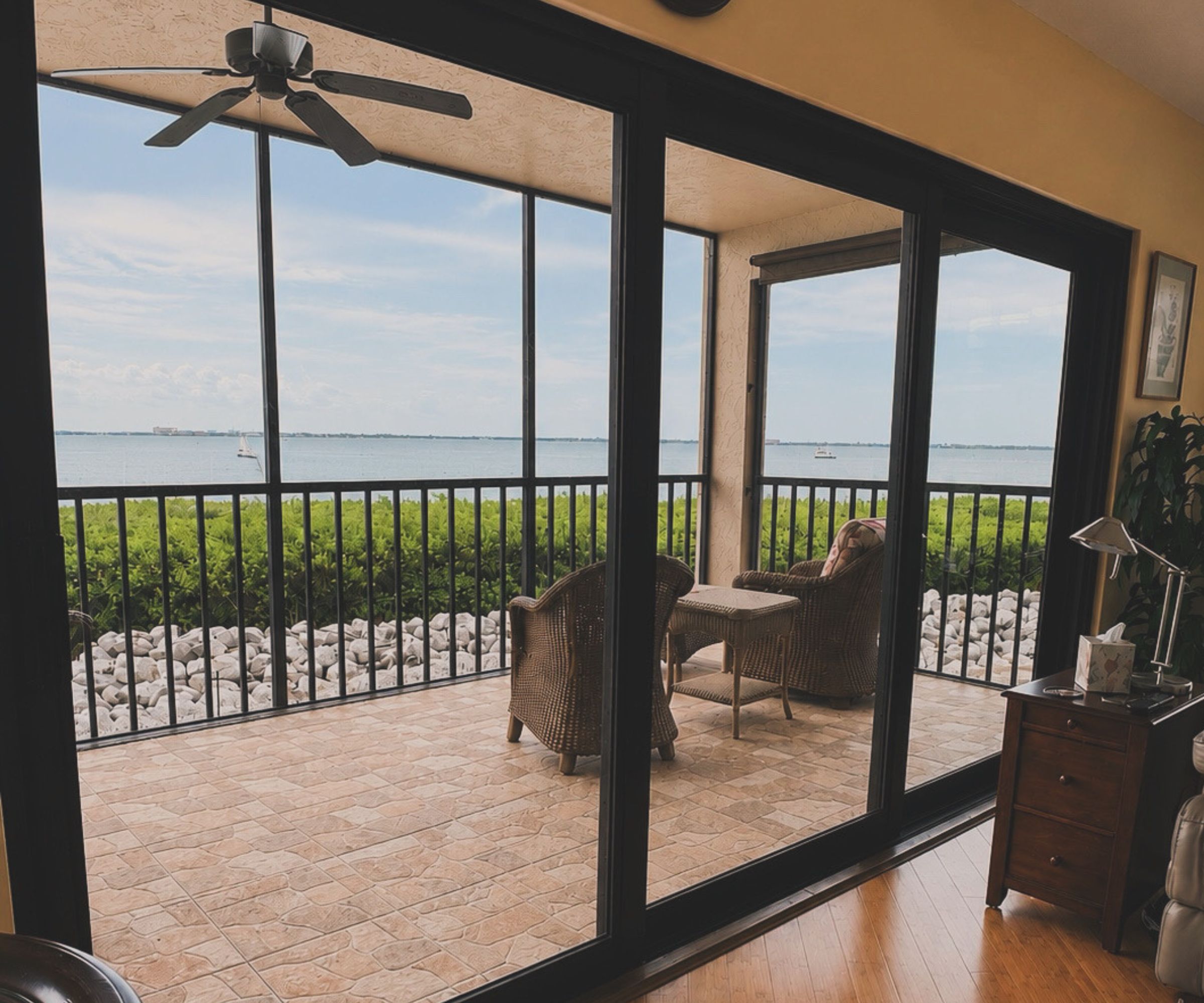 Screened lanai enclosure with sliding glass doors overlooking the bay
