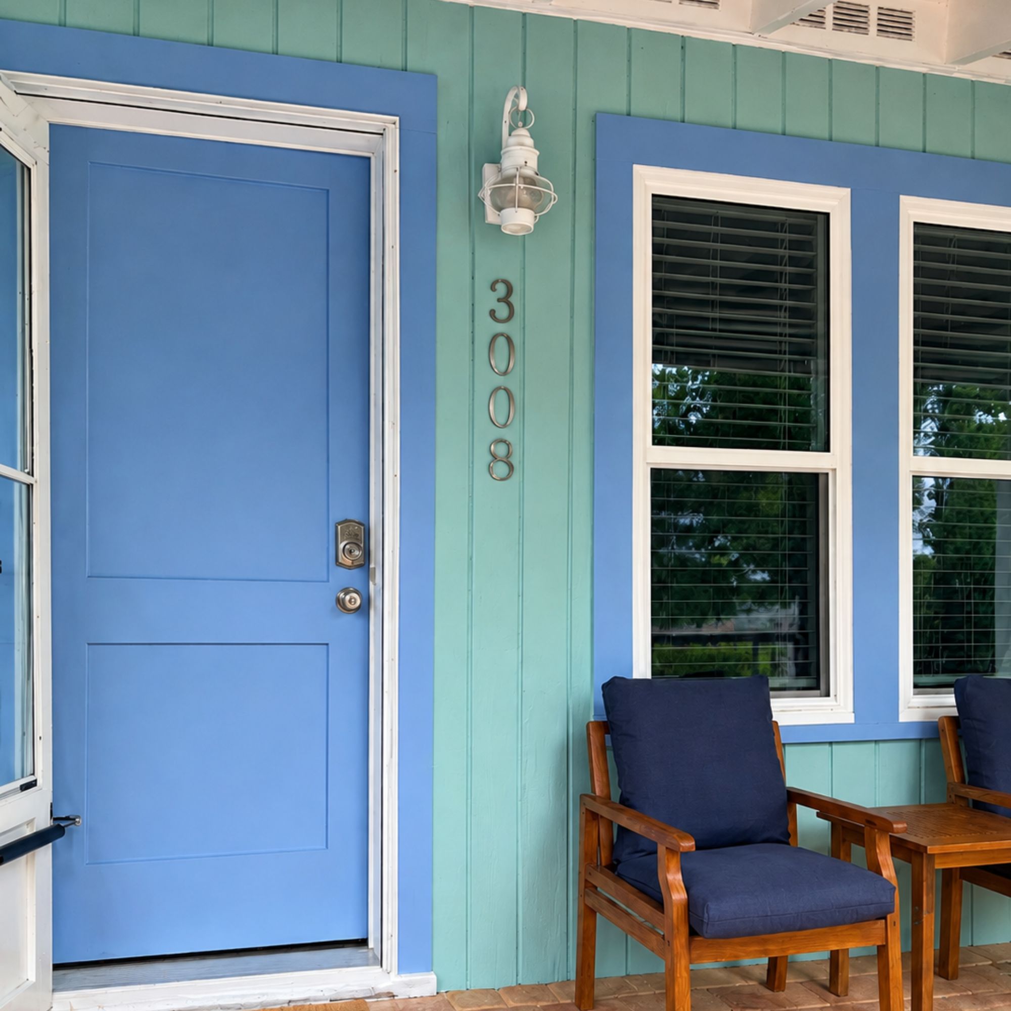 Blue board and batten siding with a matching front door and house numbers