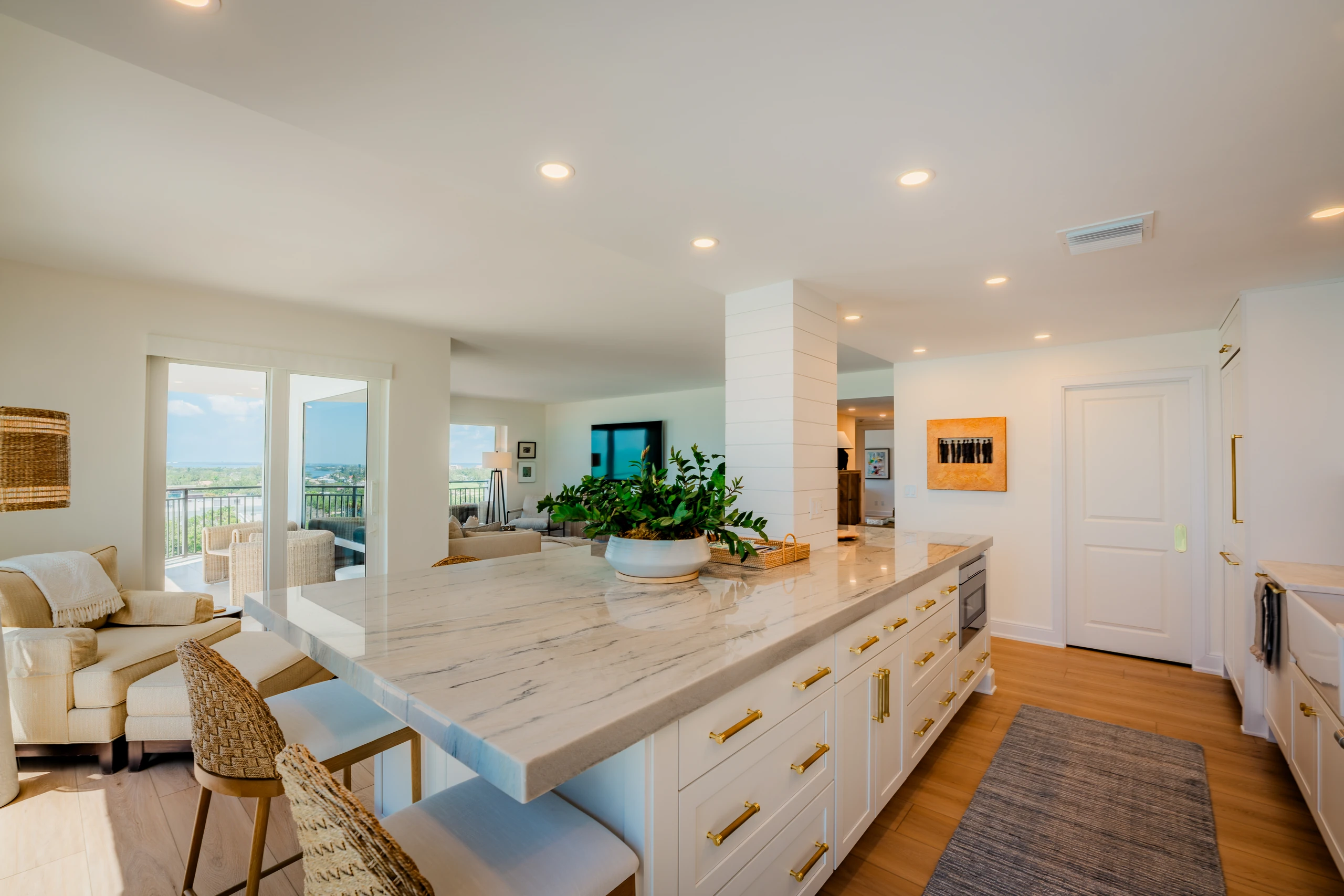 Remodeled open-plan kitchen with a marble island and gulf views beyond