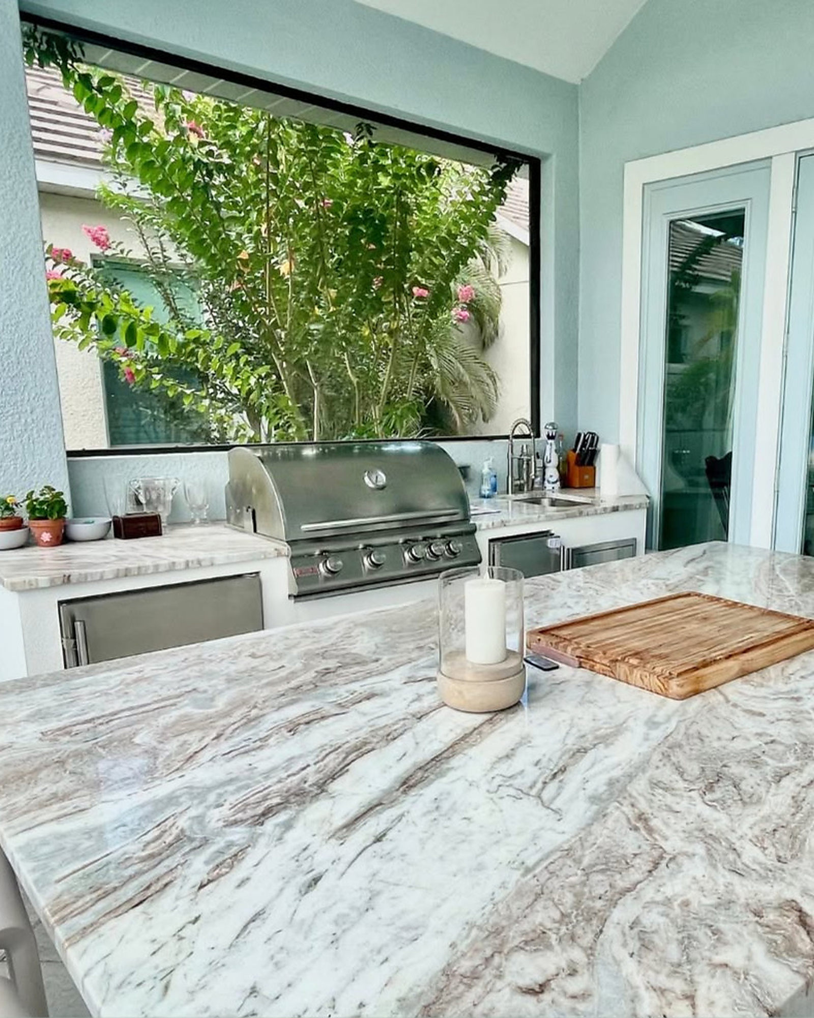 Outdoor kitchen with a built-in grill and a pass-through window to the garden