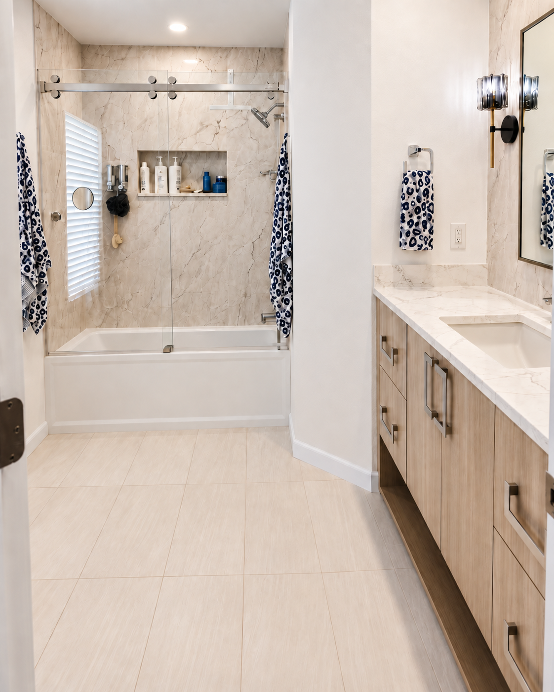 Bathroom with a marble-look tub surround, sliding glass door and wood vanity