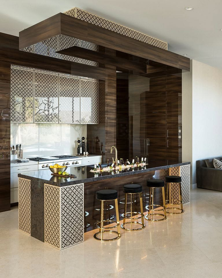 Luxury kitchen with a patterned inlay island, walnut cabinetry and gold bar stools