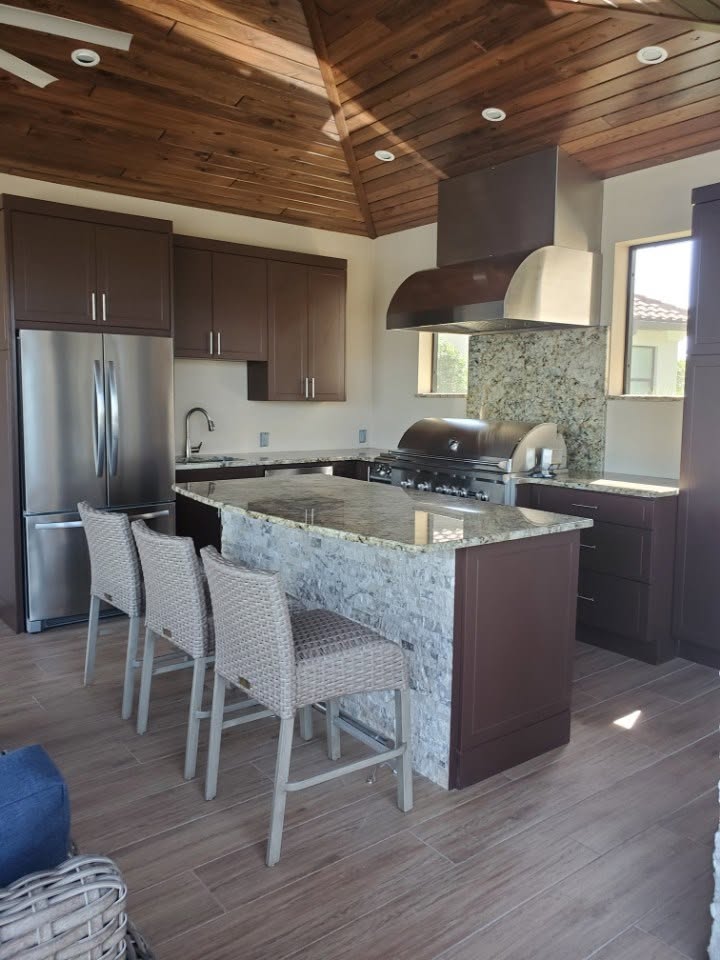 Kitchen with a granite island, espresso cabinets and a wood plank vaulted ceiling