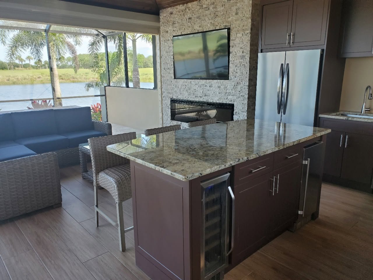 Lanai kitchen with granite island, wine fridge and lake views through screened windows