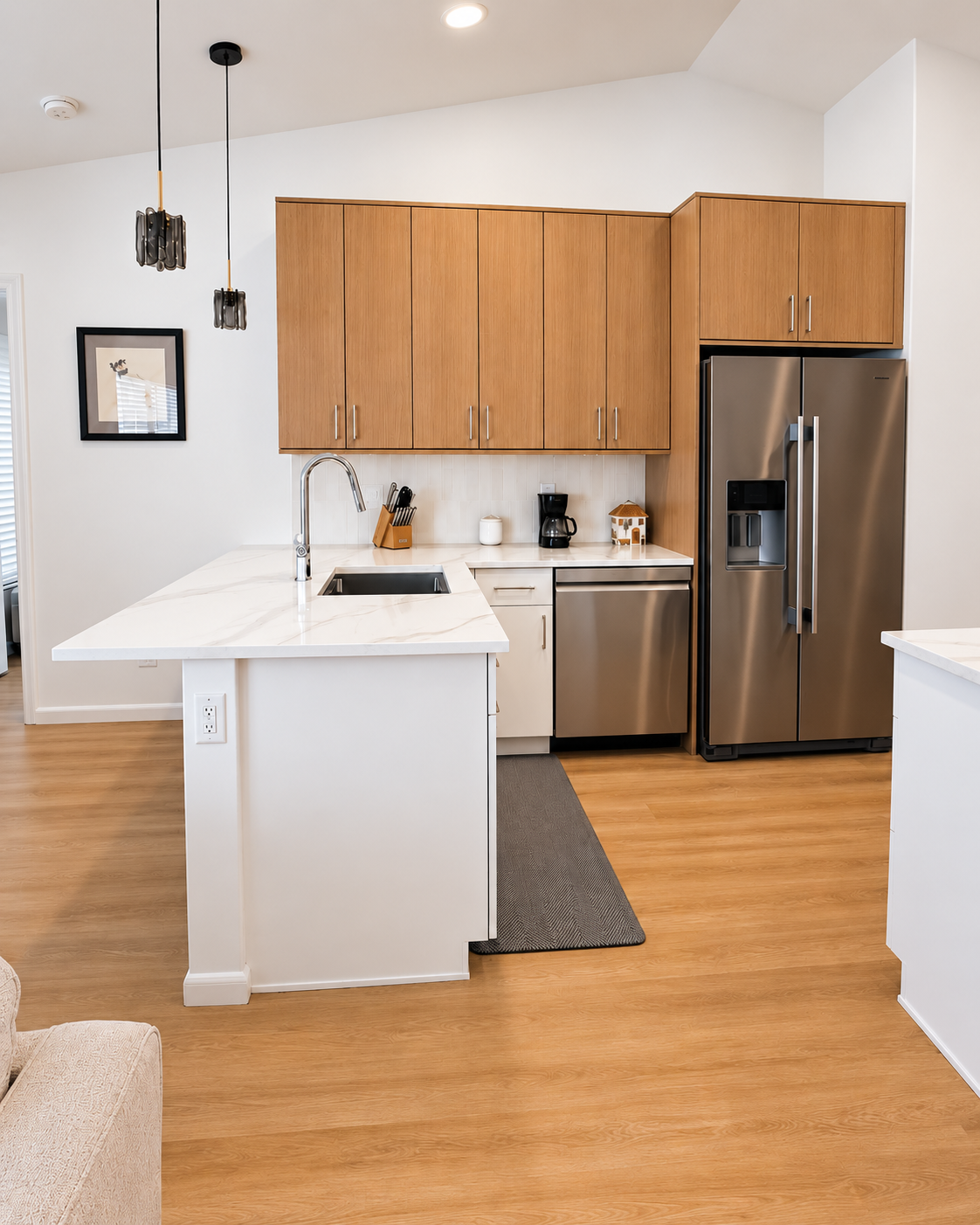 Kitchen with an oak upper cabinets, quartz island and stainless appliances