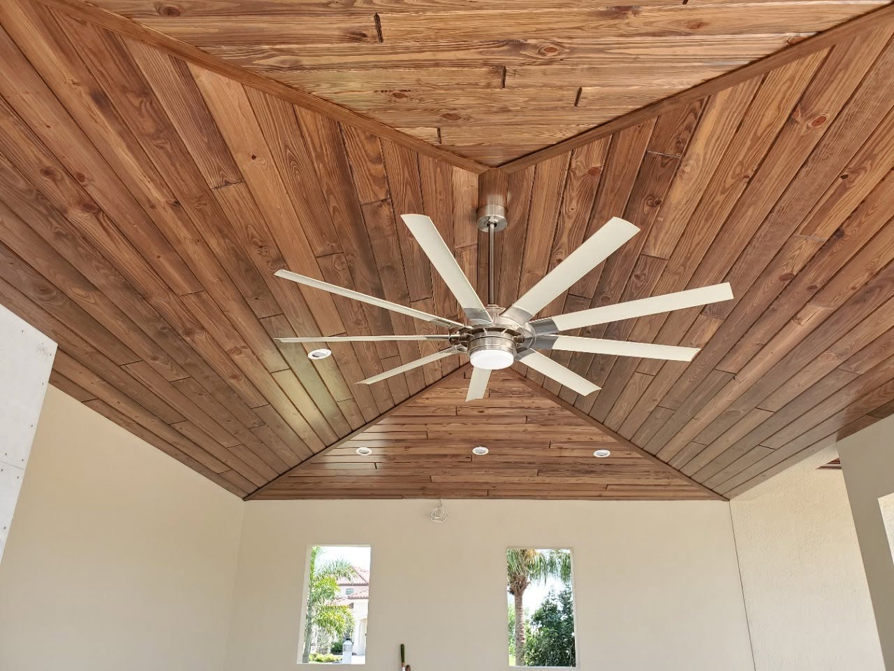 Vaulted tongue-and-groove wood ceiling with a large ceiling fan