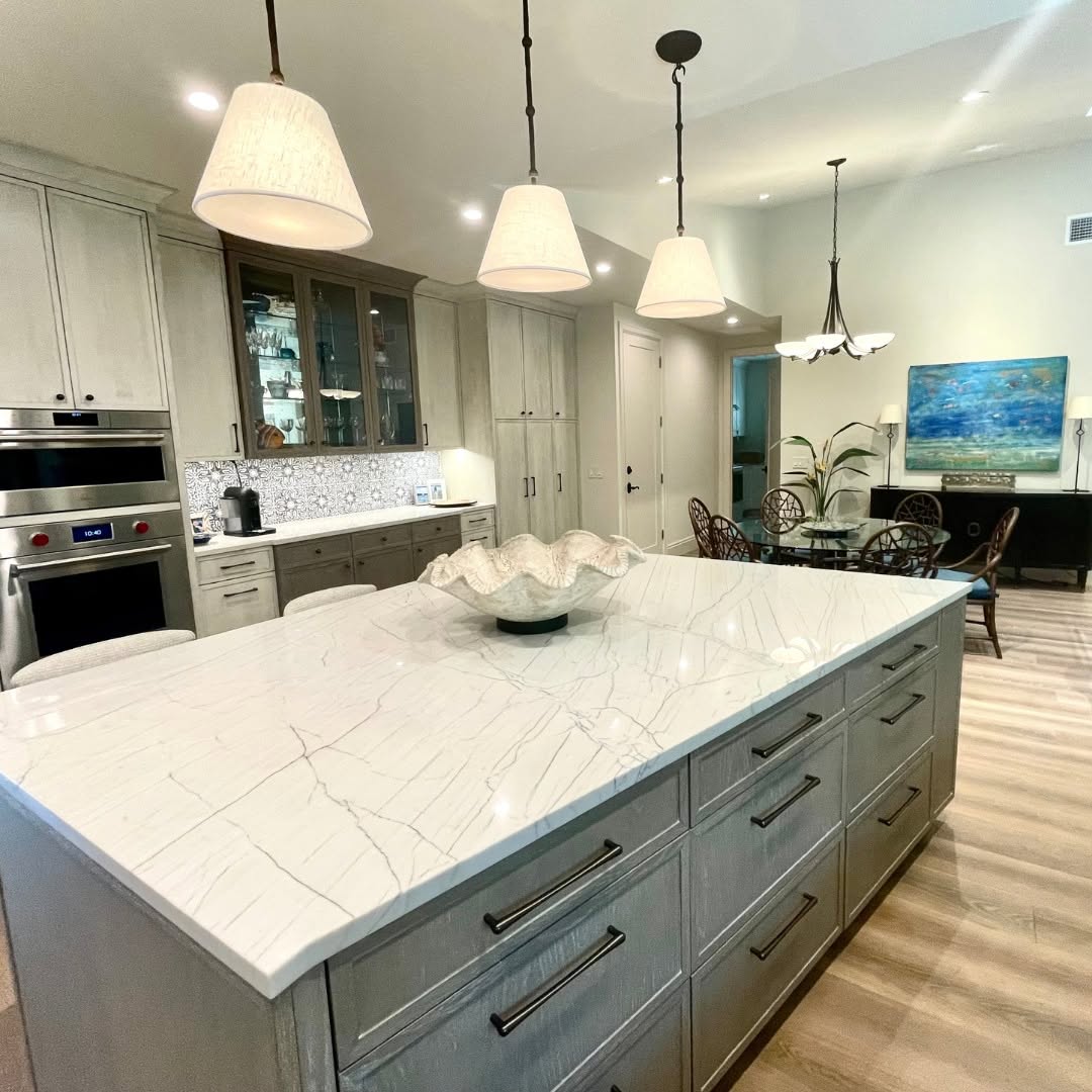 Kitchen island with a marble-look quartz waterfall top and gray cabinetry