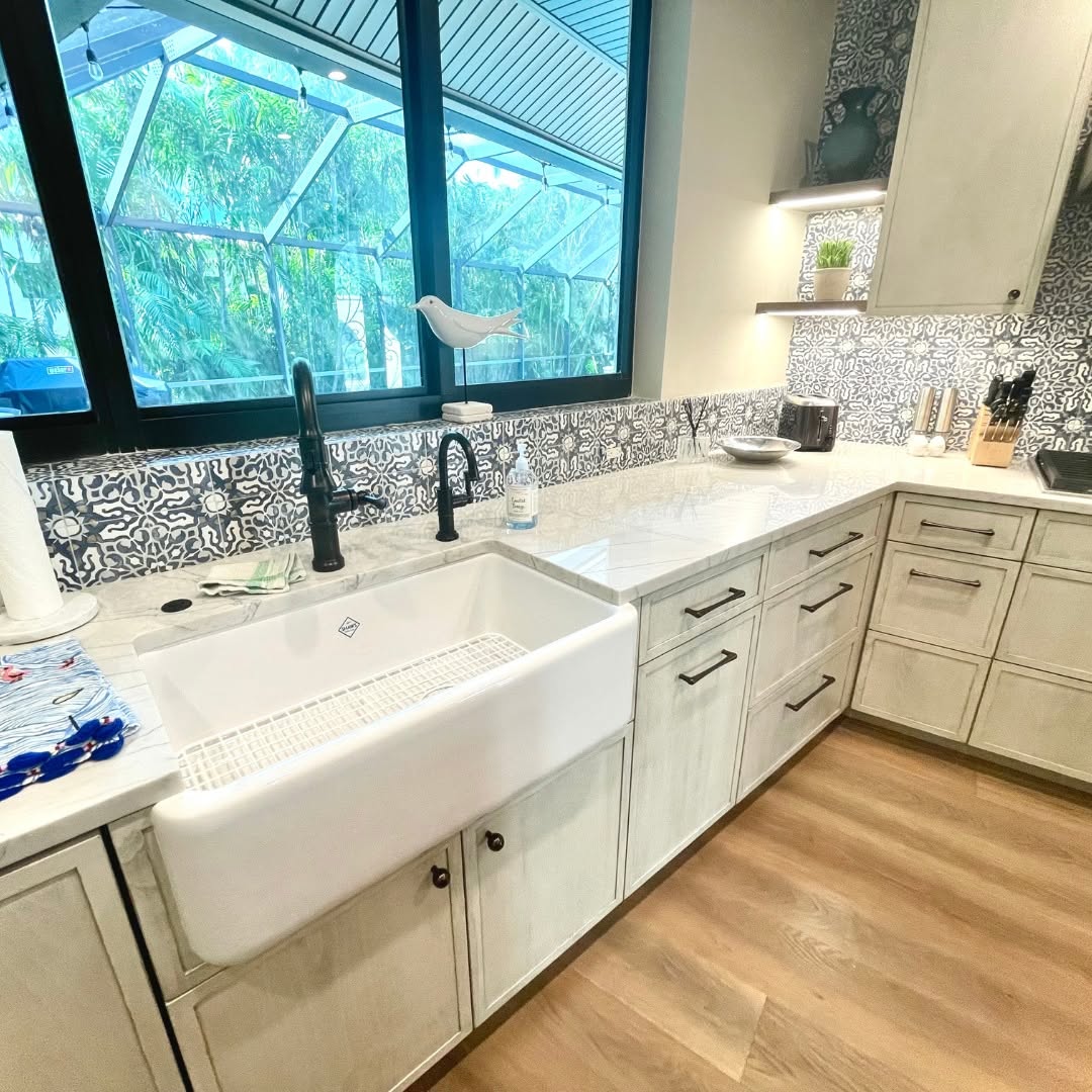 Kitchen with a farmhouse sink, patterned tile backsplash and lanai window