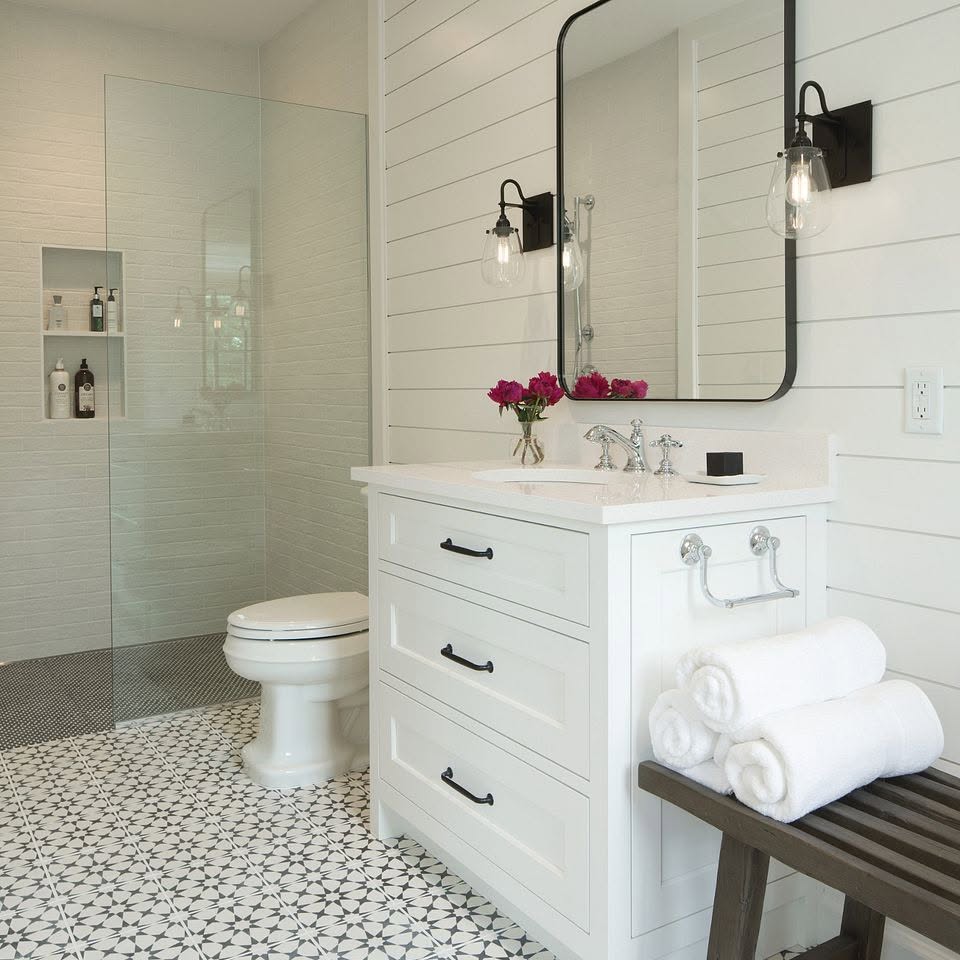 Bathroom with shiplap walls, patterned tile floor and a curbless glass shower