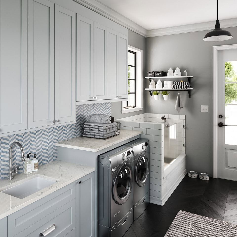 Laundry room with gray cabinets, herringbone tile backsplash and a built-in dog wash
