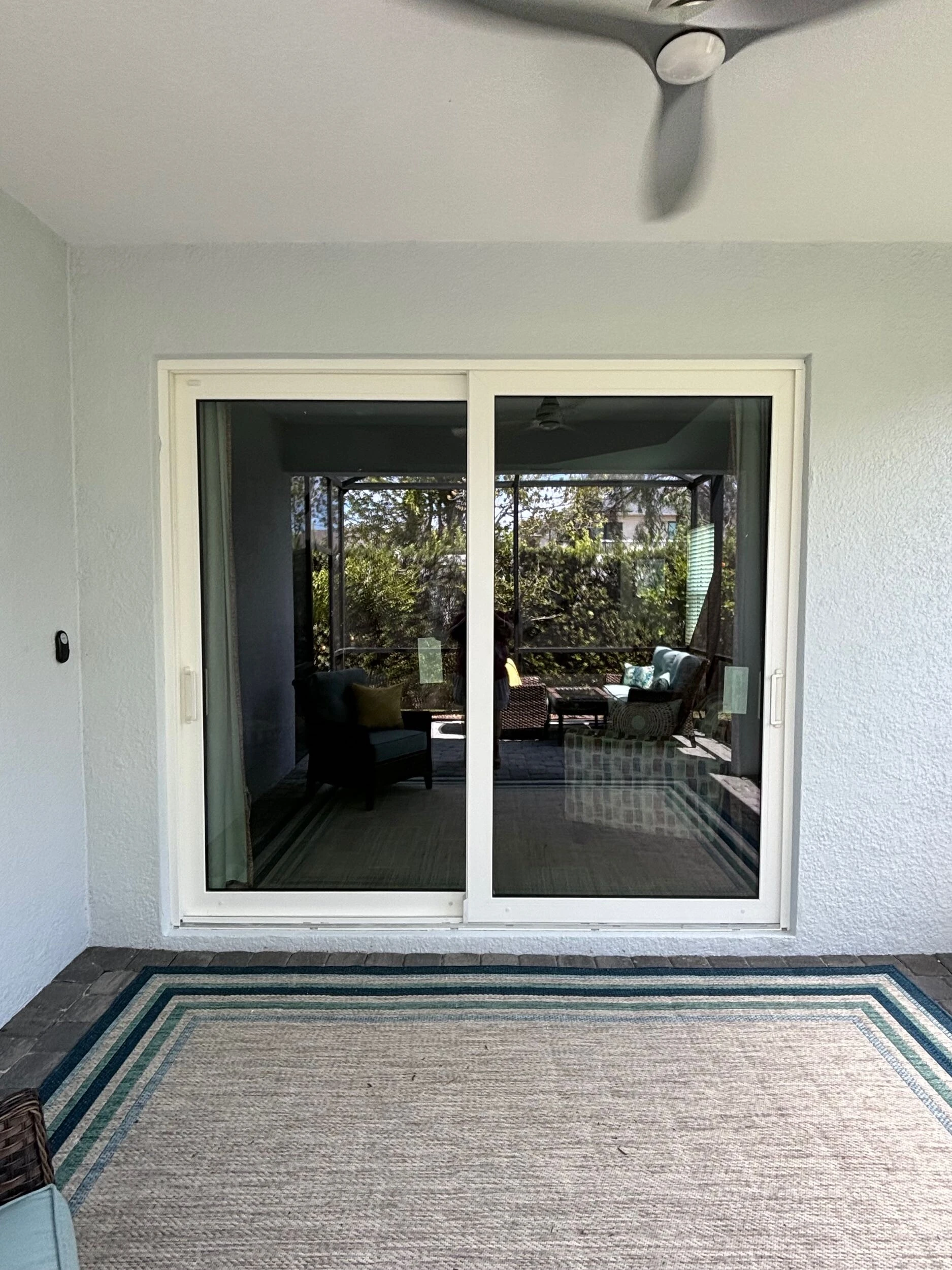 Sliding glass door leading from a living room to a screened porch
