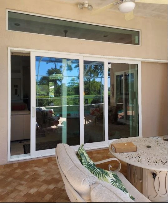 Sliding glass doors with transom windows opening onto a screened lanai