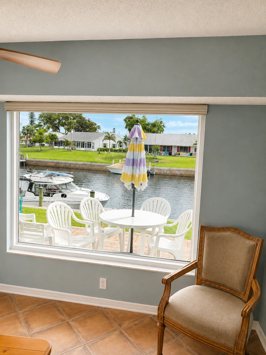 Picture window overlooking a canal with boat docks and patio seating