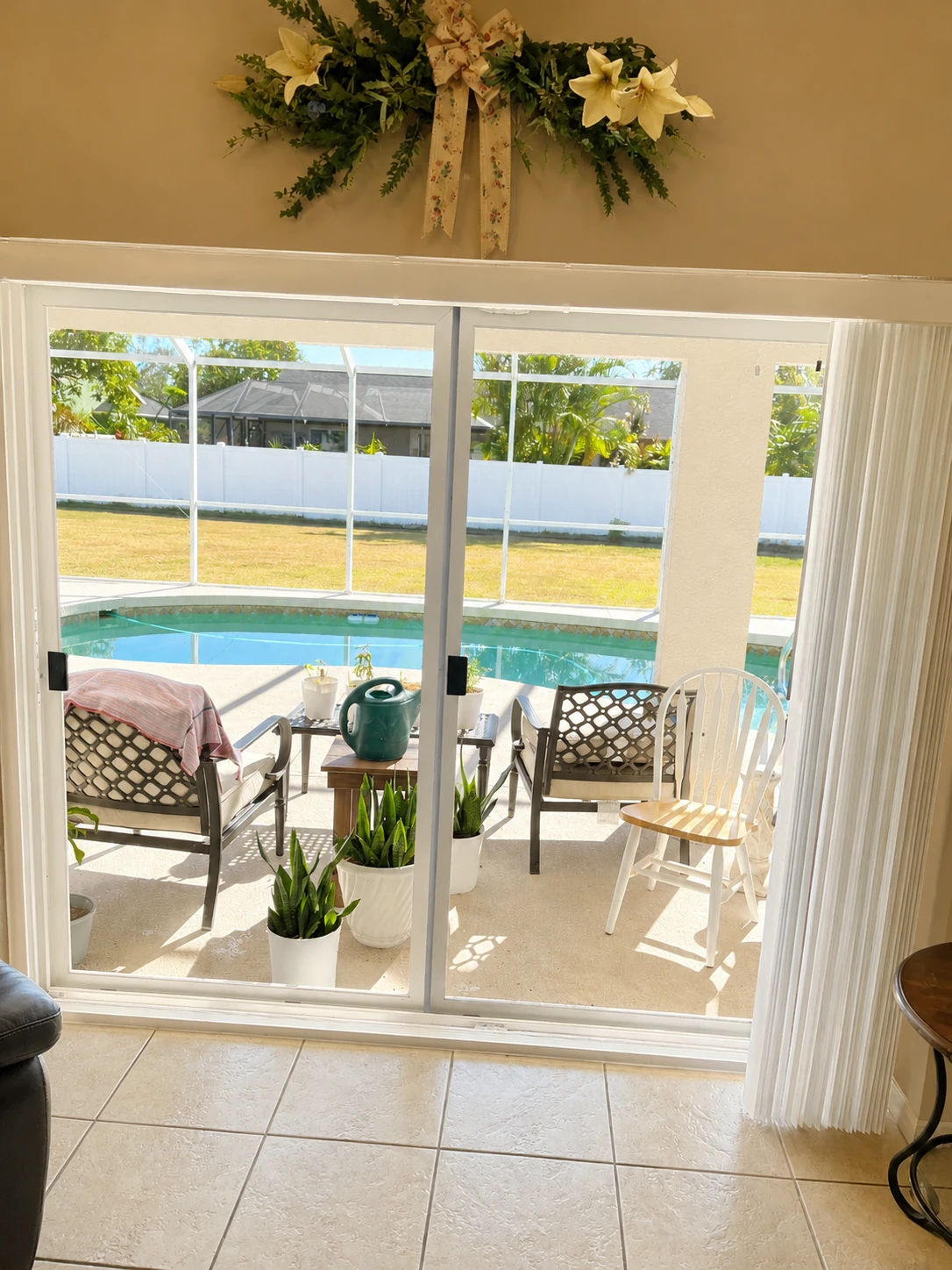 Sliding glass door looking out to a screened pool enclosure and patio