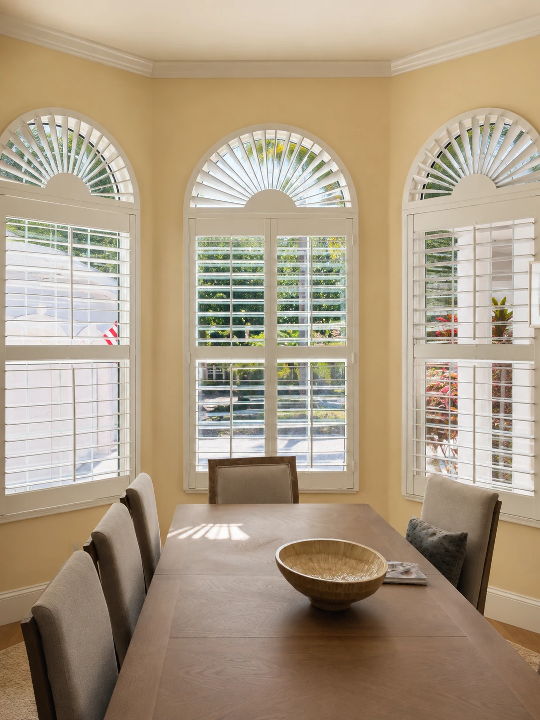 Dining room with arched windows and white plantation shutters