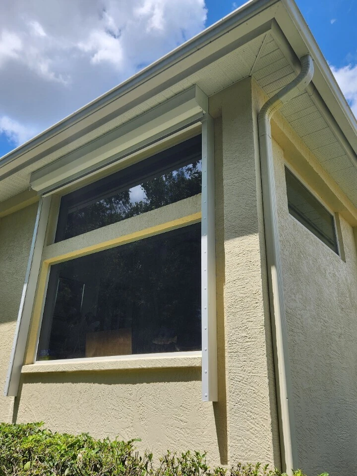 Awning window propped open on a stucco home exterior