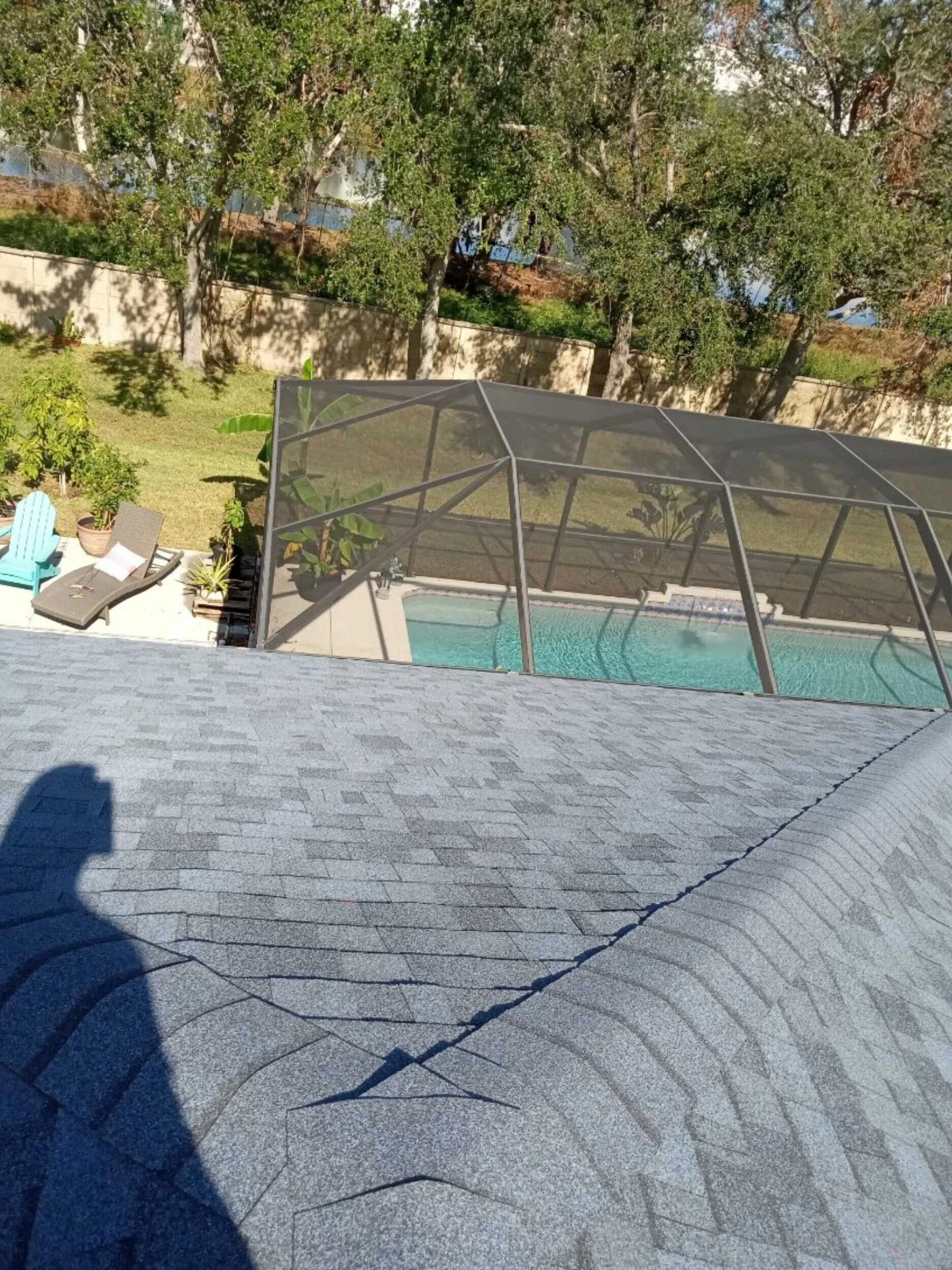 New asphalt shingle roof overlooking a screened pool enclosure