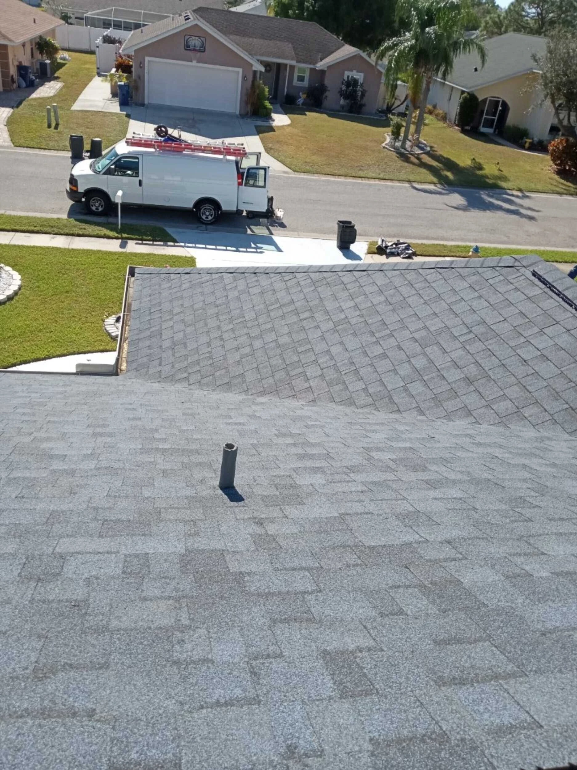 Grayhawk Remodeling work van parked outside a home during a shingle roof replacement