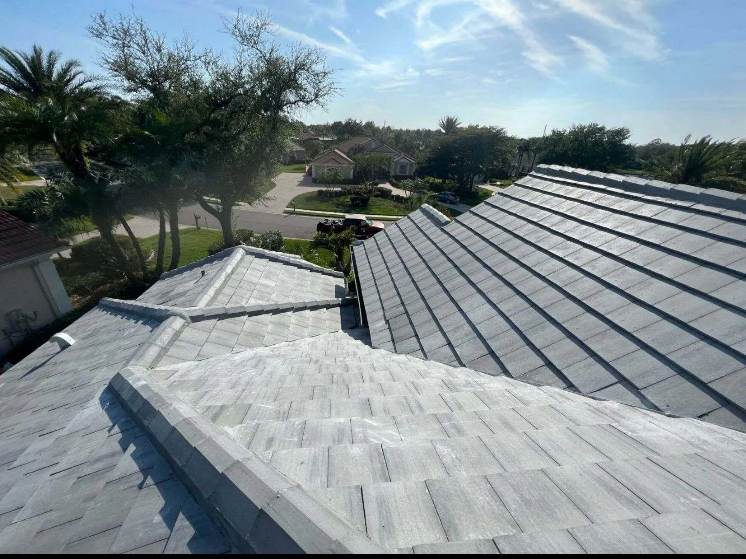 Tile roof replacement in progress with underlayment exposed on the adjoining roof section