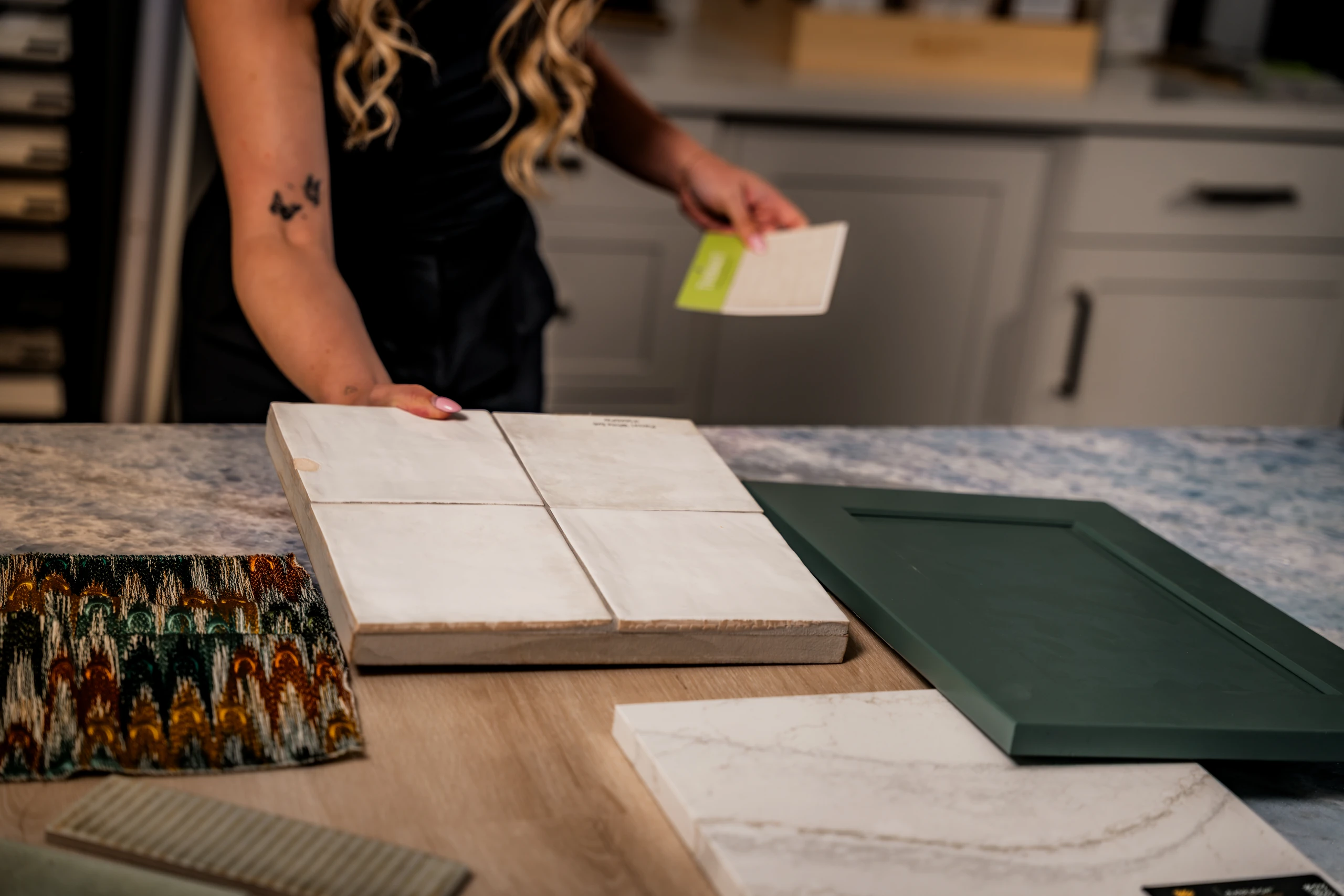 Designer laying out tile, cabinet and countertop samples on a work surface
