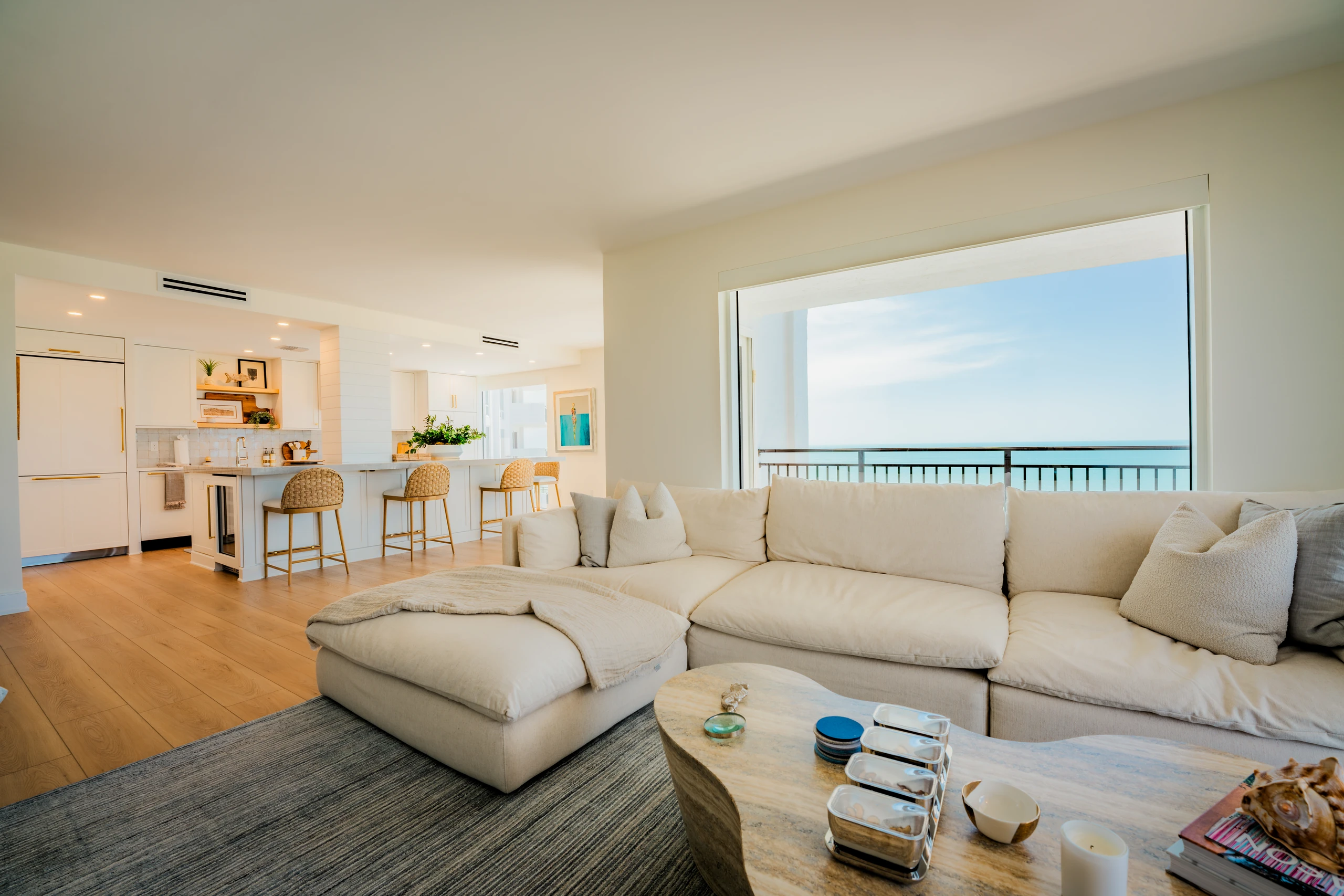 Open living room and kitchen with a sectional and Gulf views beyond