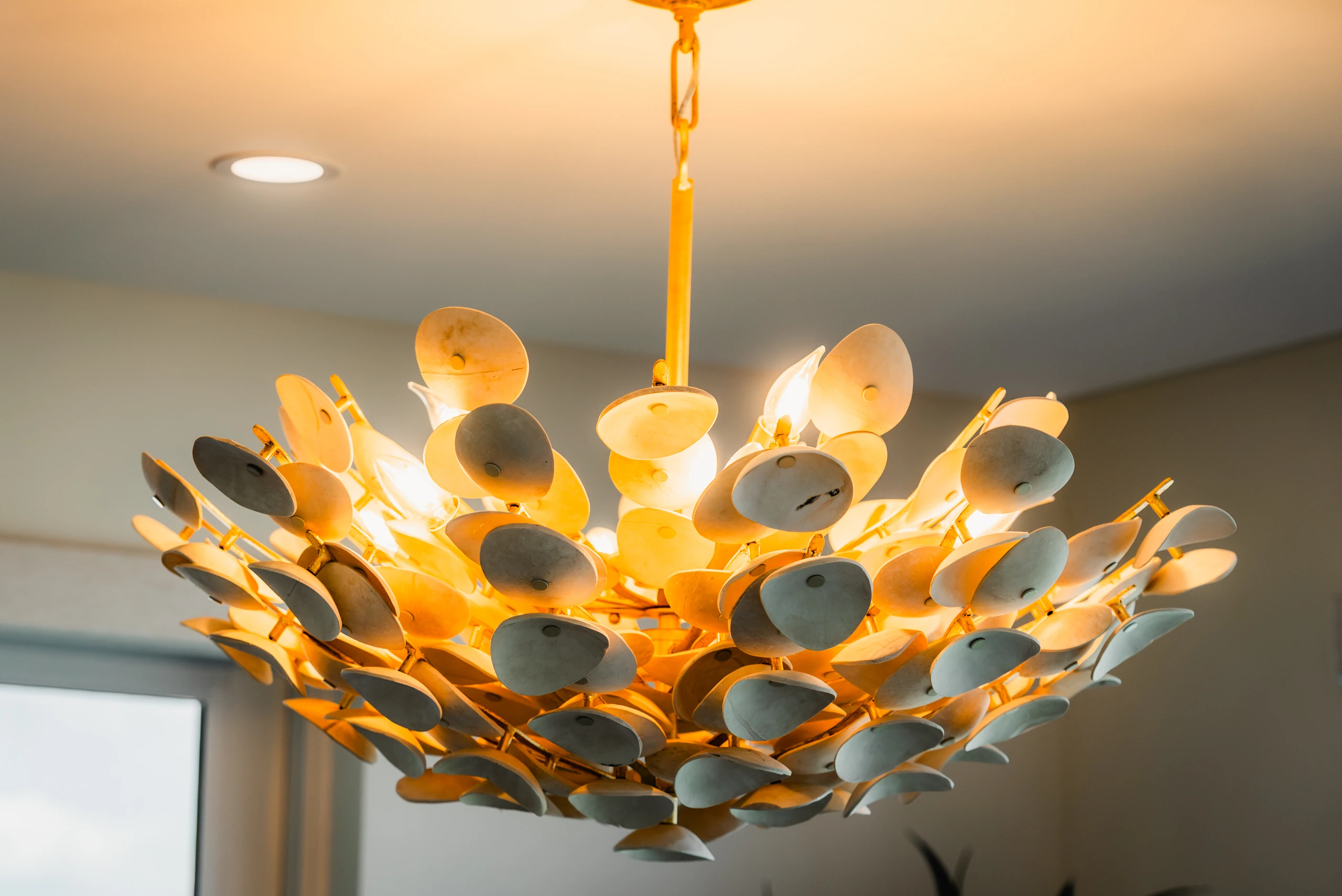 Capiz shell chandelier lighting a room from a white ceiling
