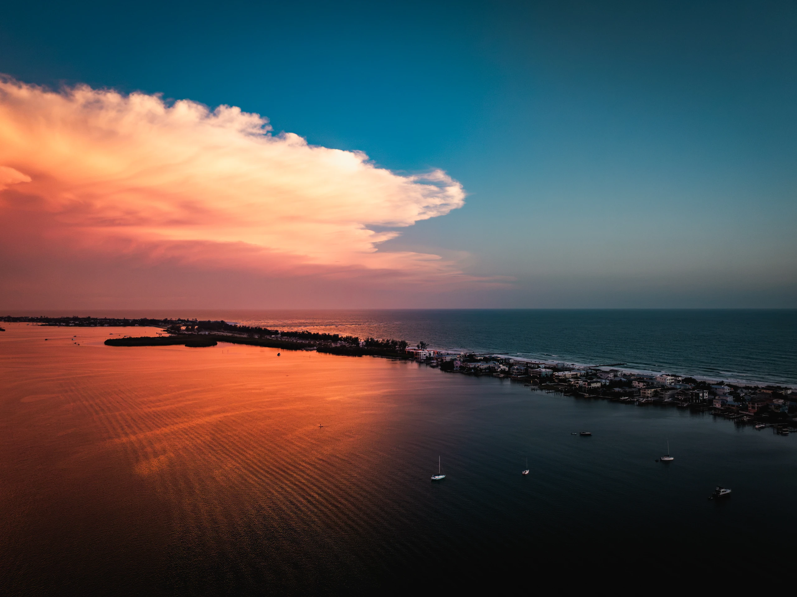 Aerial view of the Gulf shoreline and a barrier island at sunset