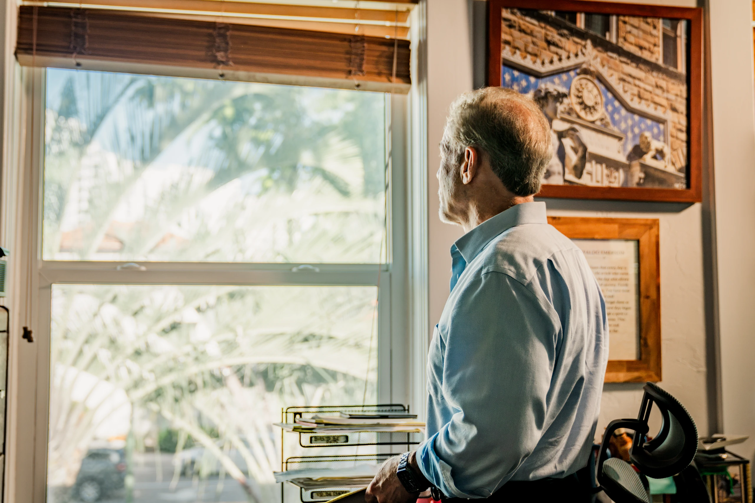 Homeowner looking out a new single hung window in his office