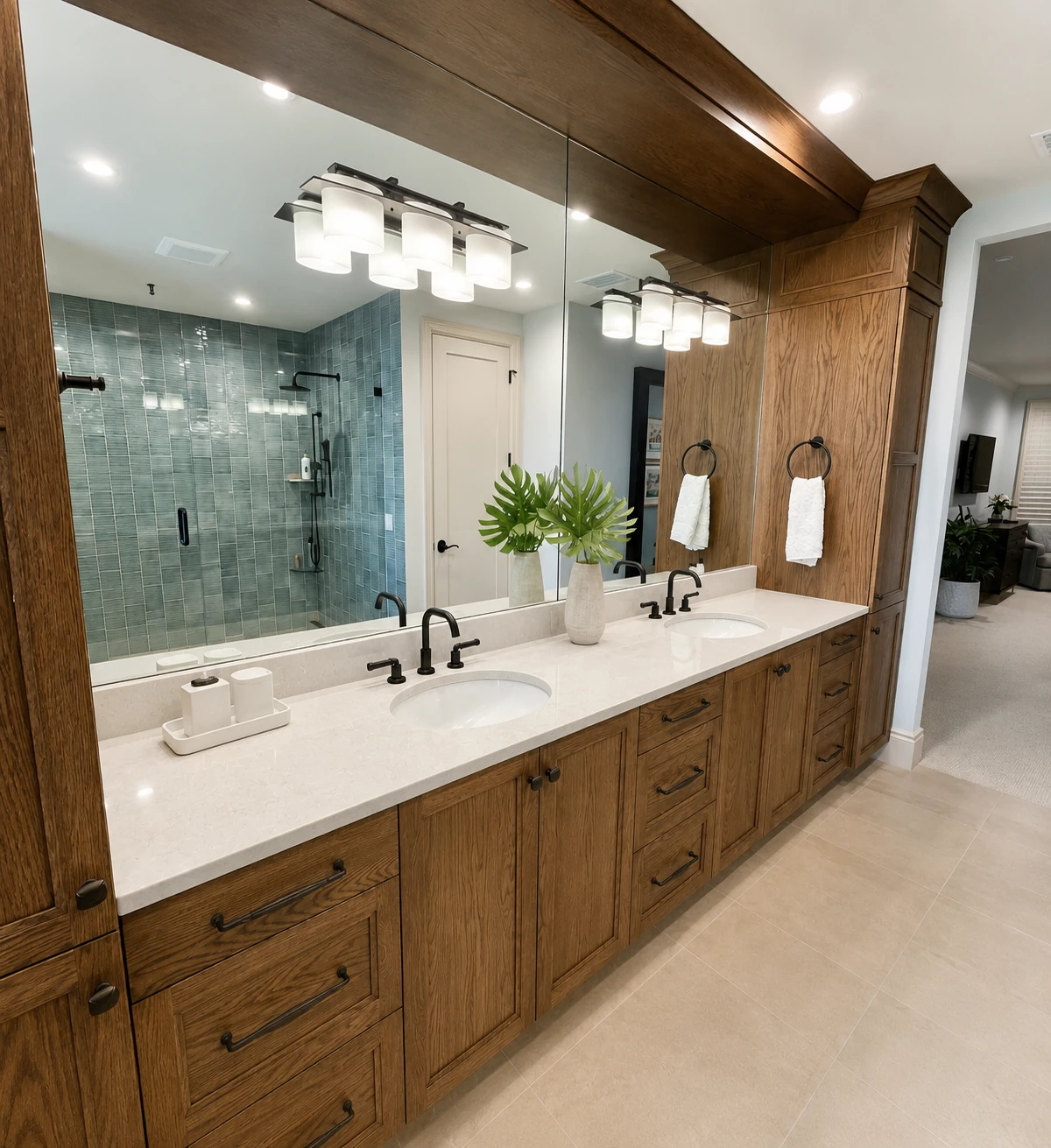 Double vanity with oak cabinetry and a blue-tiled walk-in shower beyond