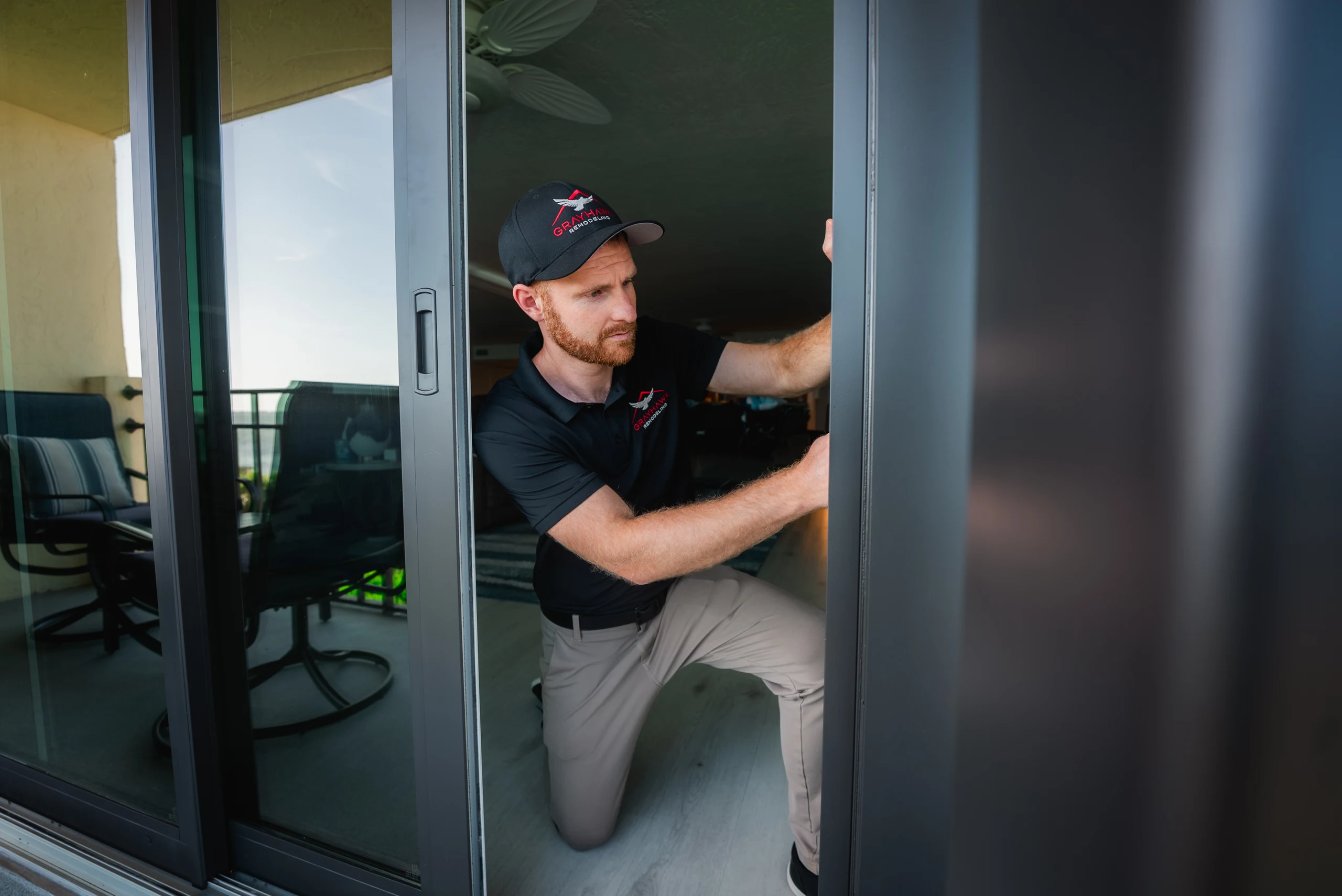 Technician adjusting a sliding glass door track during a home repair