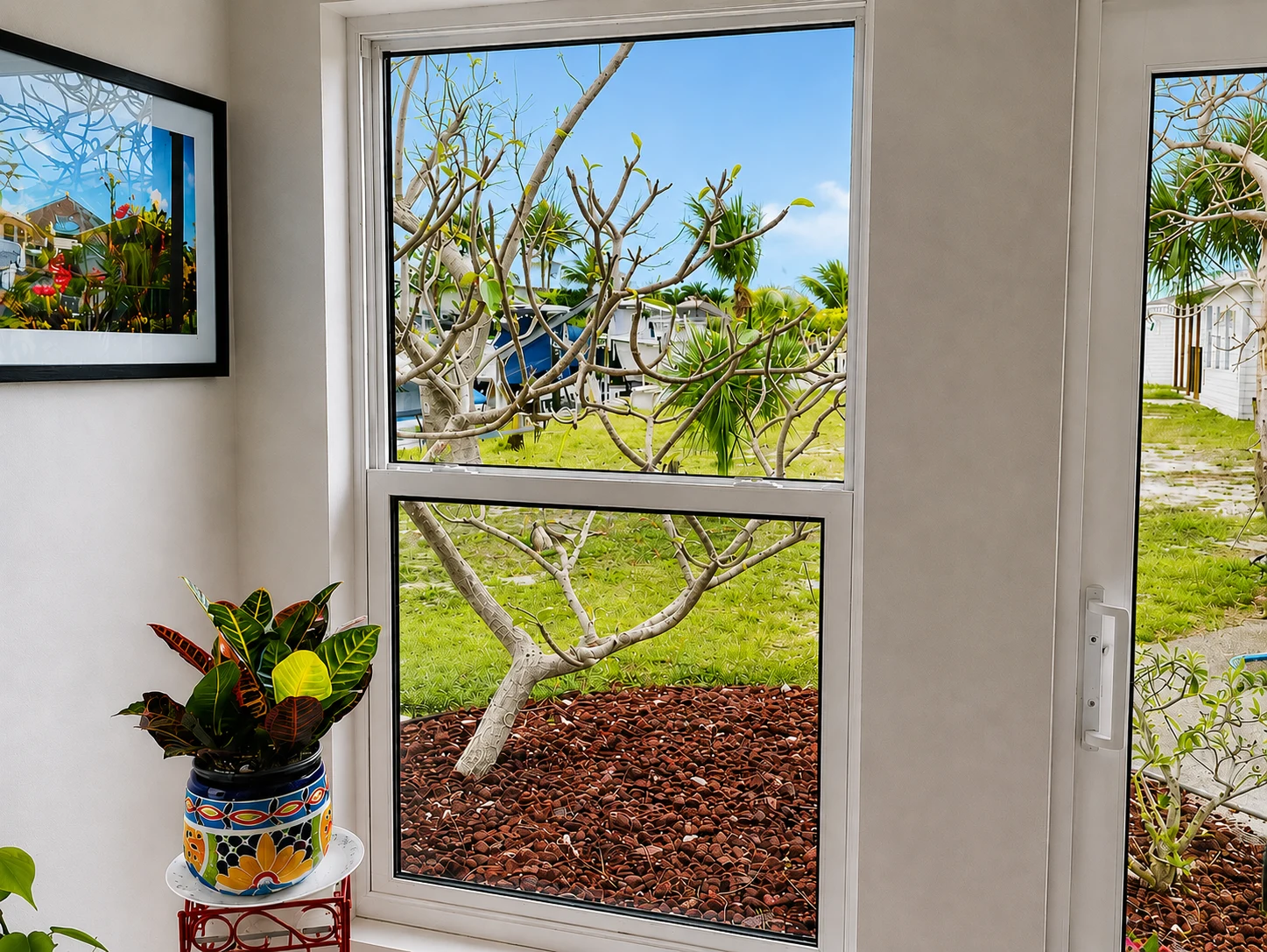 White vinyl single hung window looking out onto a landscaped yard