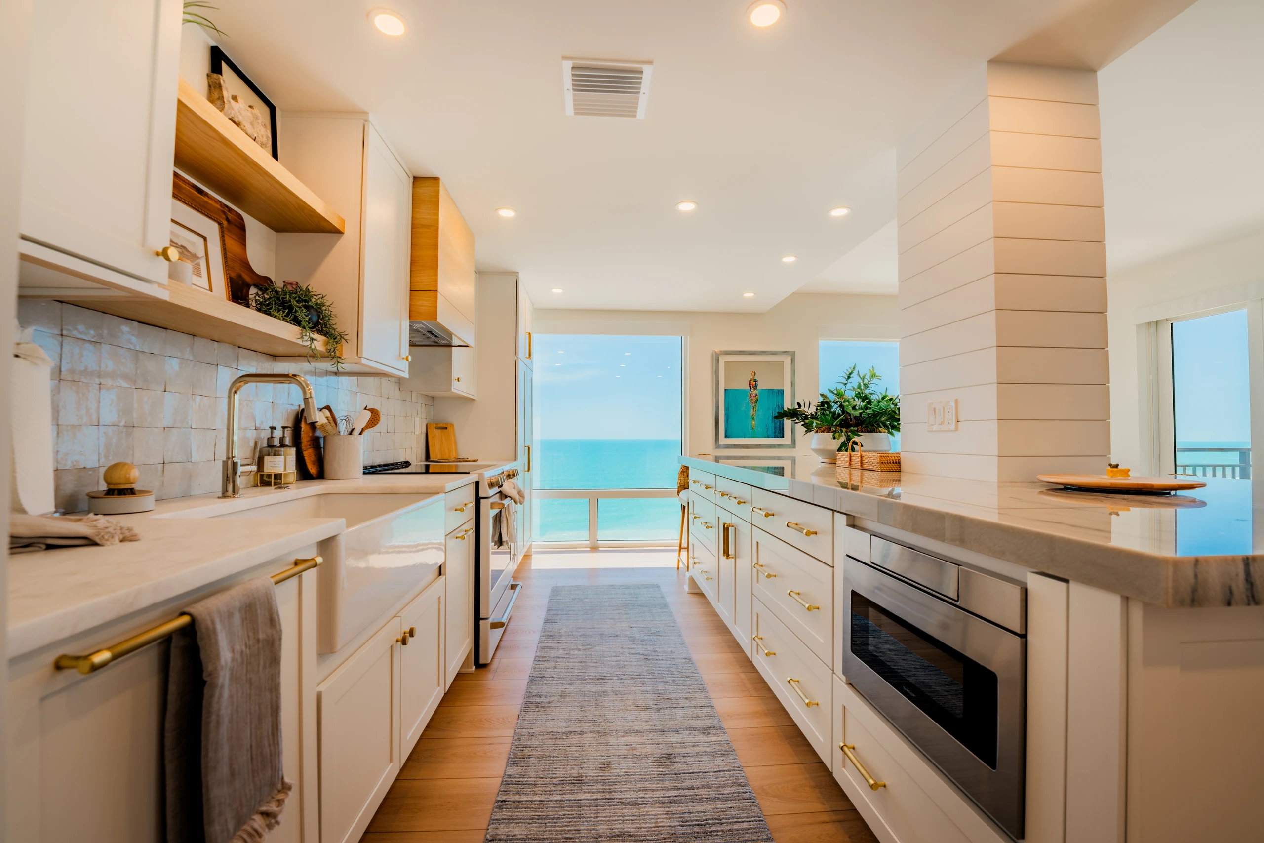 Galley kitchen with a farmhouse sink and gulf view at the end of the run