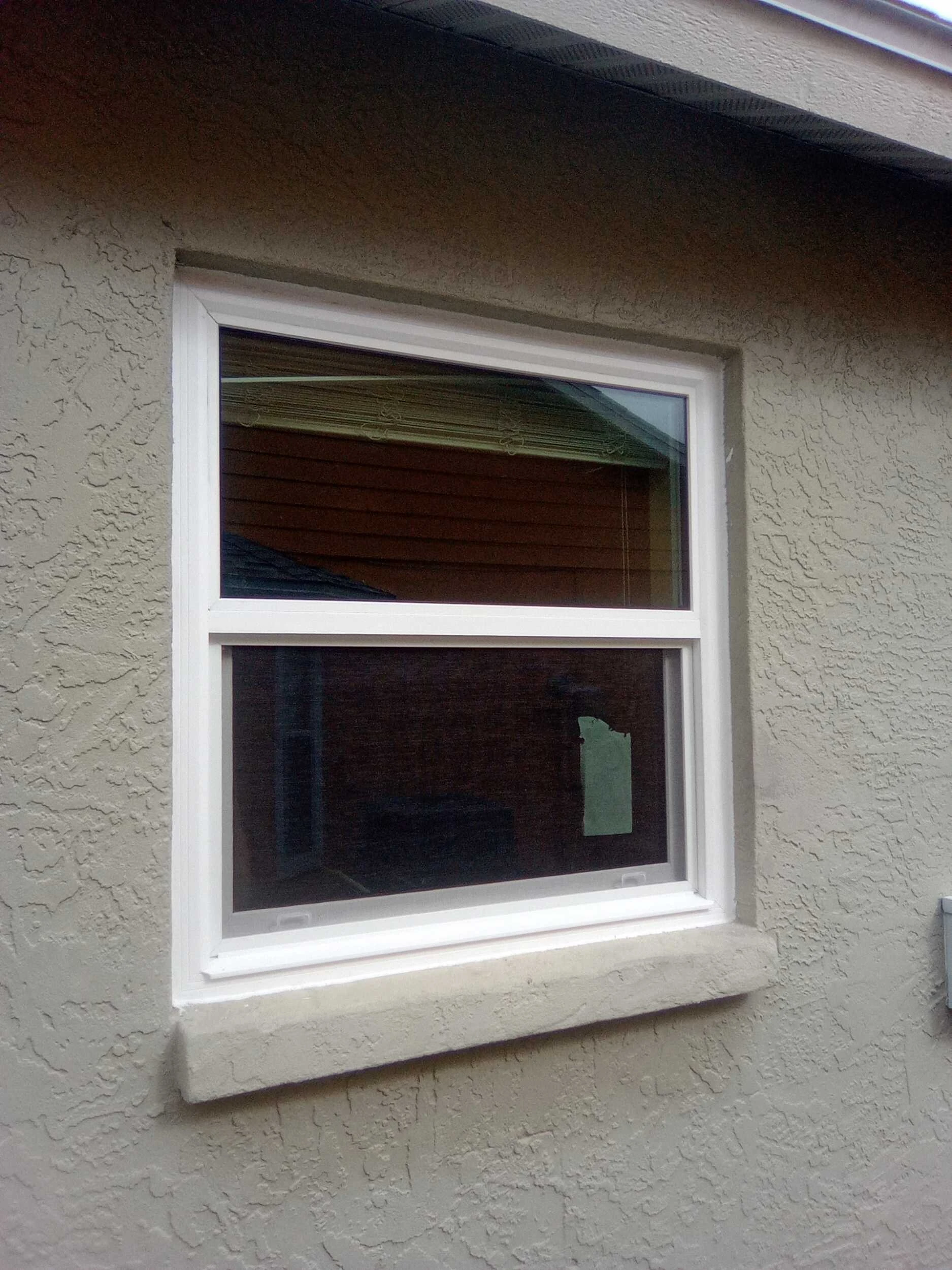New single hung window installed in a beige stucco wall
