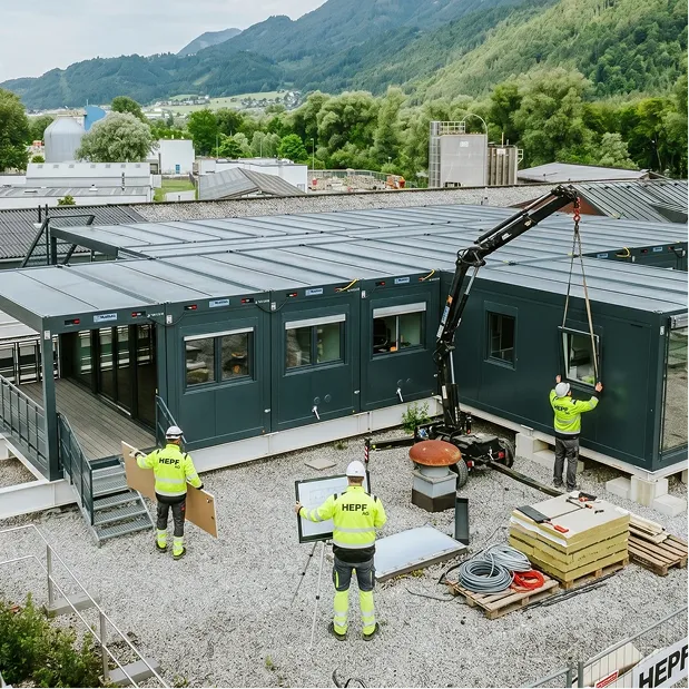 Contruction crew working together to assemble a modular container complex