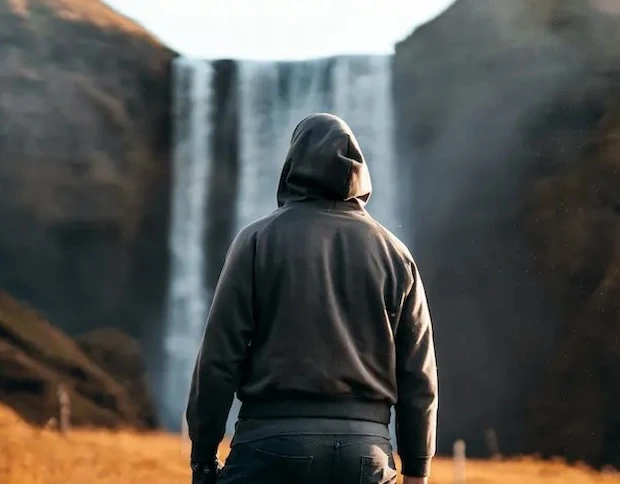 Guy standing in front of a waterfall