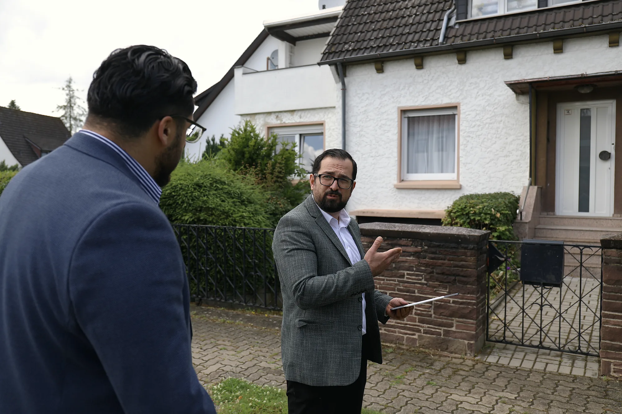 Beratungsgespräch vor einem Wohnhaus