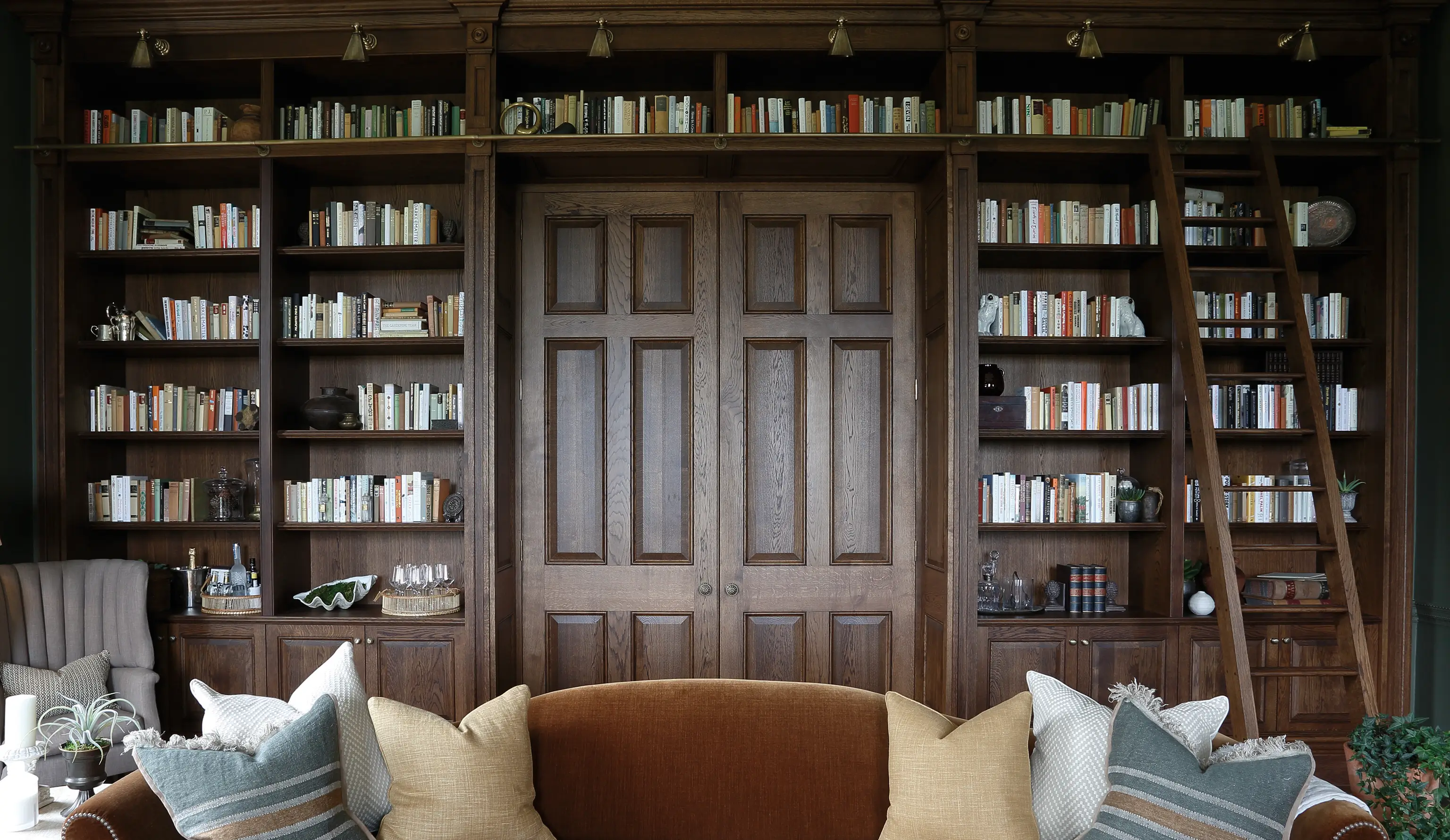 bespoke library cabinet integrated with architectural doors and a rail and ladder.