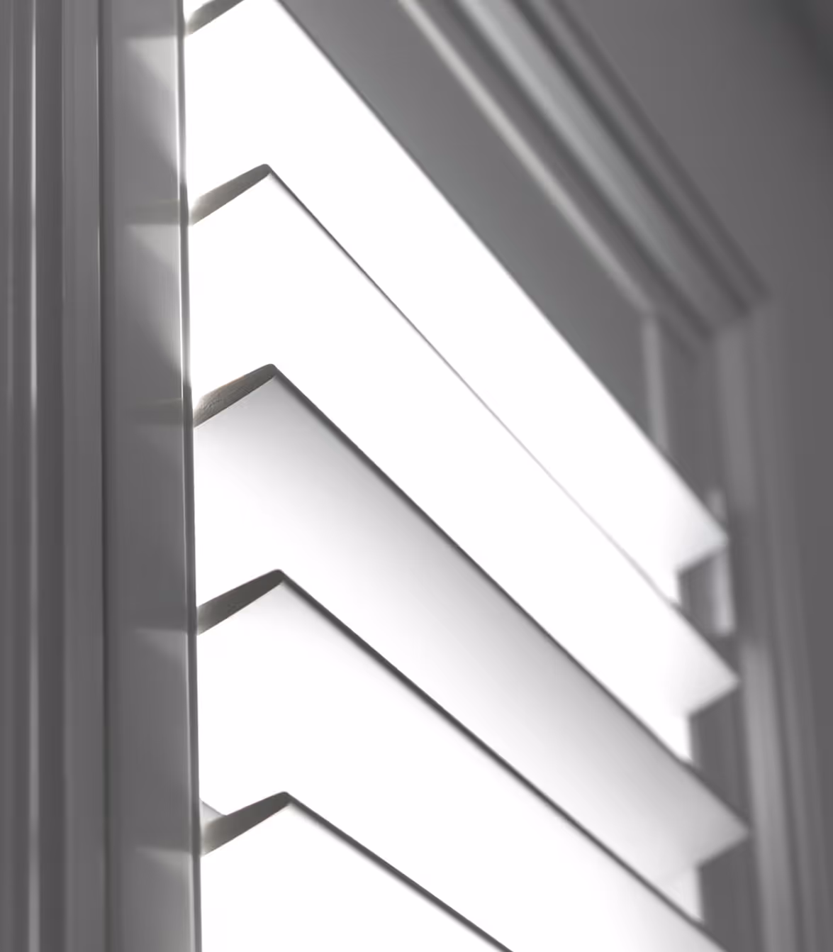 Close-up of white plantation shutters on a window with light shining through.