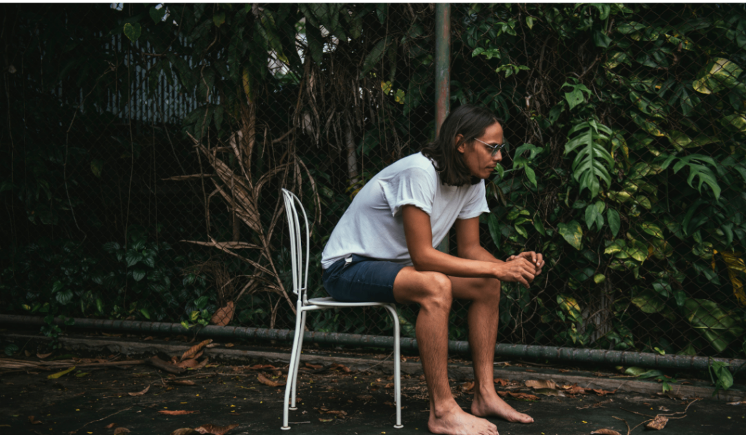 Person sitting alone looking emotionally overwhelmed, reflecting the need for emotional support.