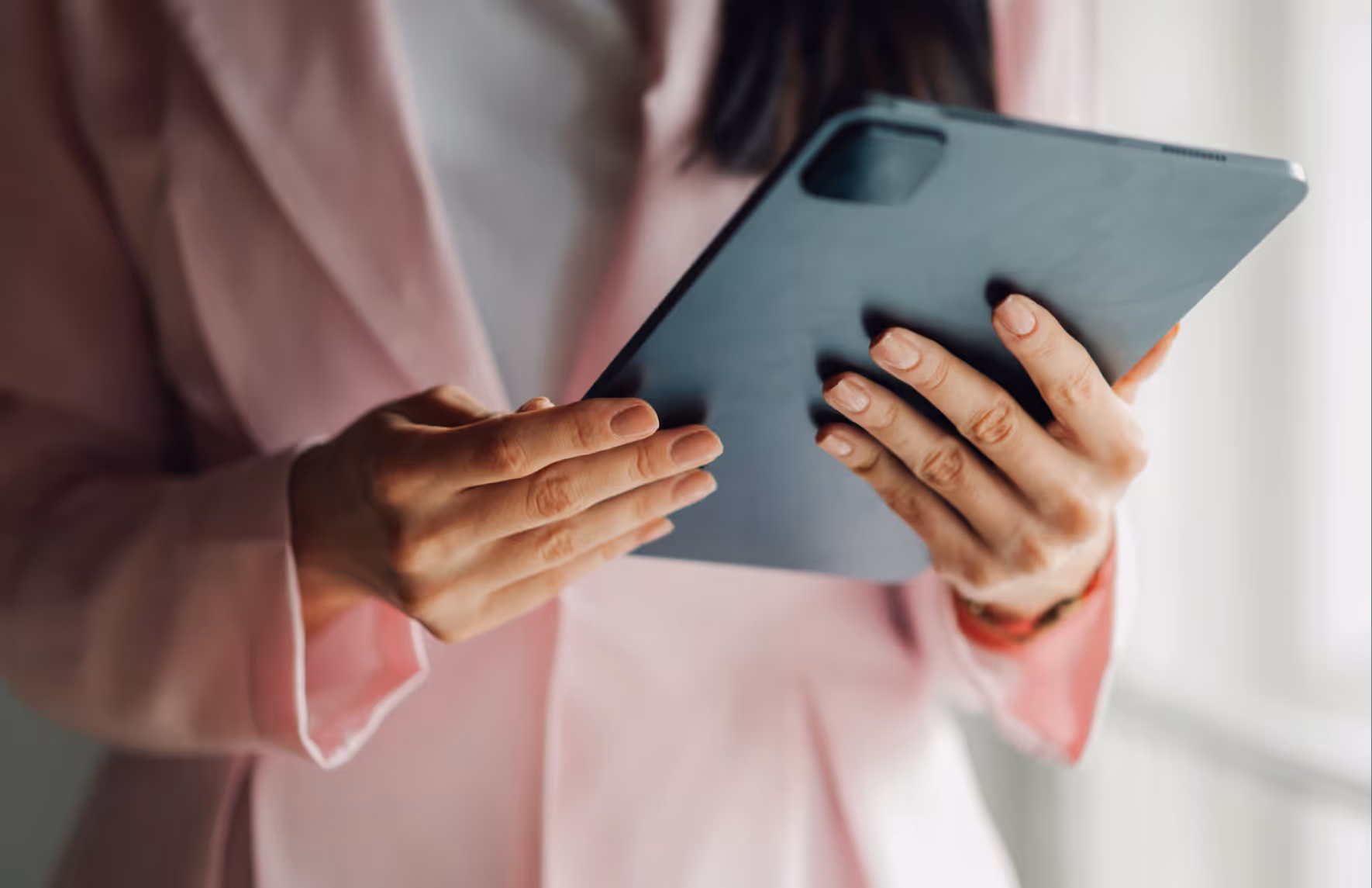 Eine Frau hält in ihren Händen ein Tablet.