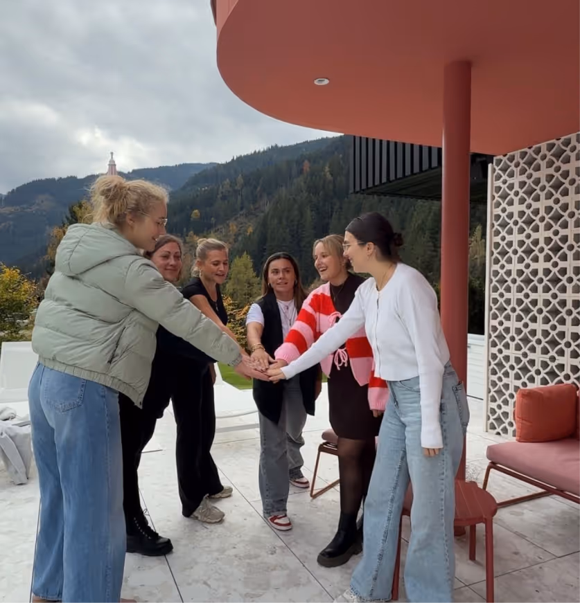 Sechs Mitarbeiter von DocMedico stehen in einem Kreis während eines Team-Building Events.