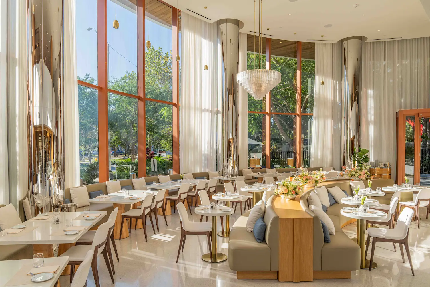 Bright modern restaurant interior with large windows, beige seating, and floral centerpieces on tables
, Mr. C Miami – Coconut Grove, luxury hotel.