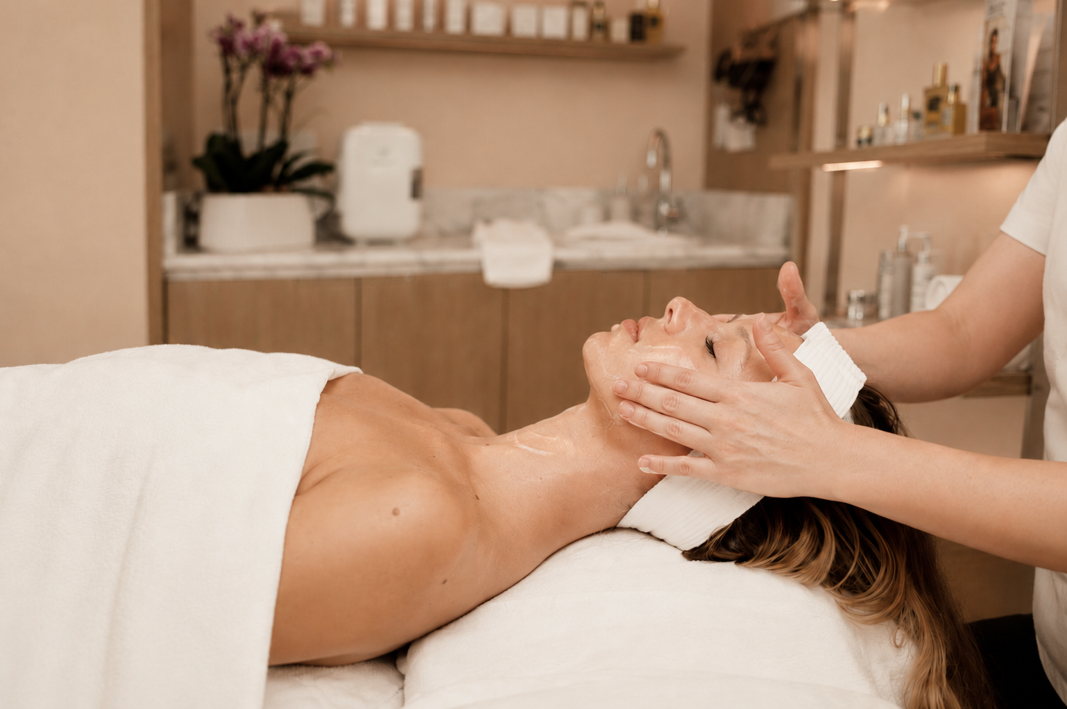 Mujer que recibe un masaje facial con mascarilla en una sala de tratamientos de spa.