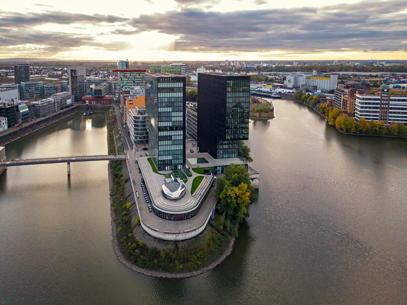 Luftaufnahme der Hafenspitze im Düsseldorfer Medienhafen mit dem Hyatt Regency Hotel zwischen den Hafenbecken bei Sonnenuntergang