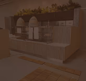 Modern kitchen counter with two beige woven dome covers, paper towel holders, and plants on top, set against a gray and wooden slat background.